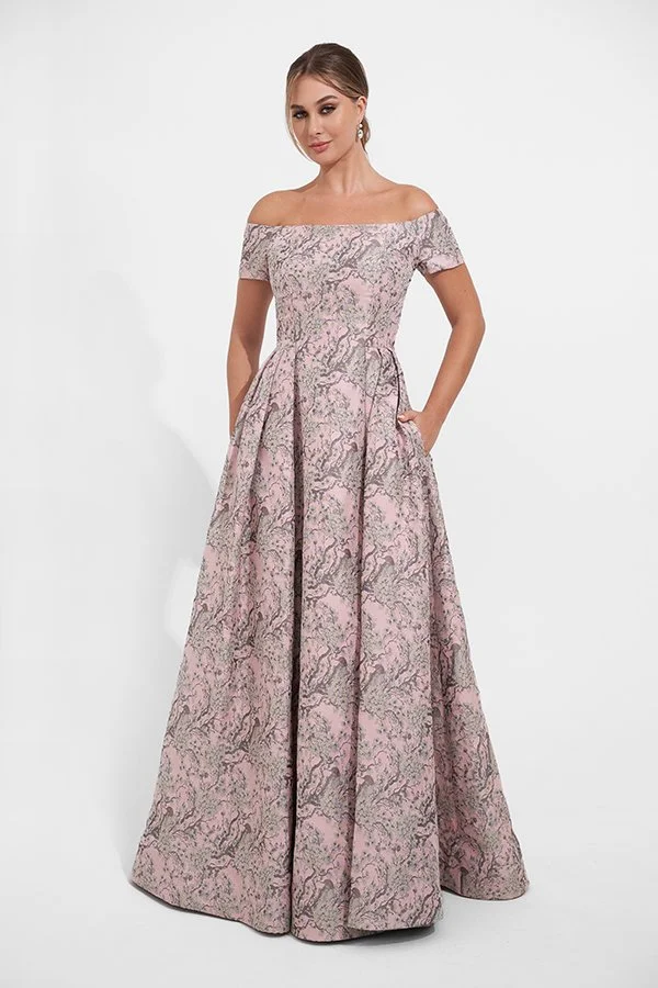 Front view of an elegant blush mother of the bride gown with an off-the-shoulder neckline, metallic jacquard fabric, hidden pockets, and a full A-line silhouette for weddings and formal events.