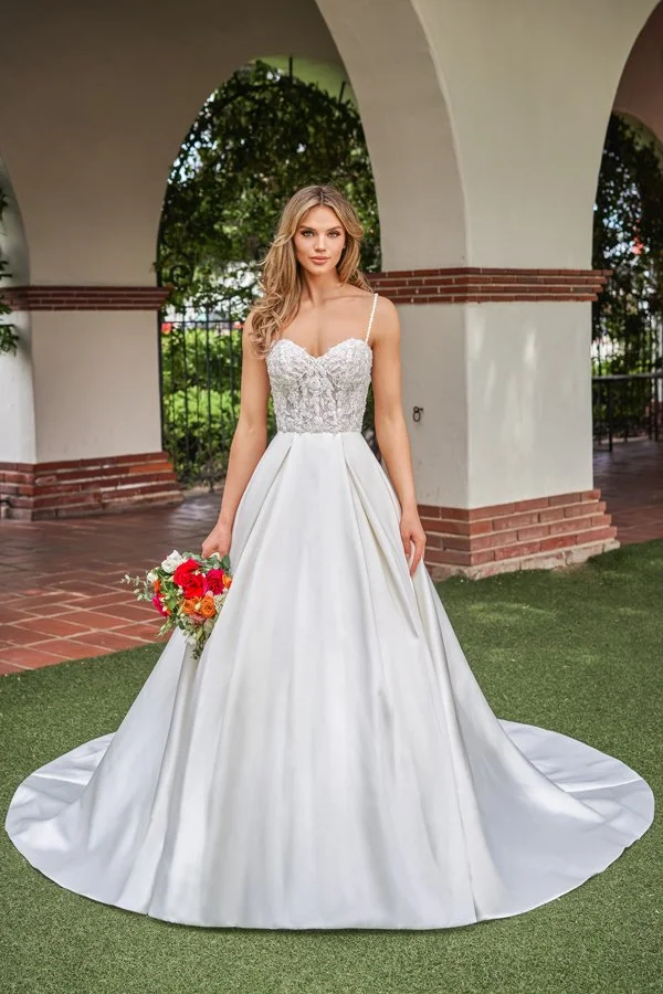 Front view of a satin A-line wedding dress featuring a floral lace illusion bodice, sweetheart neckline, delicate spaghetti straps, and a full sweeping skirt, paired with a colorful bridal bouquet for a timeless bridal look.