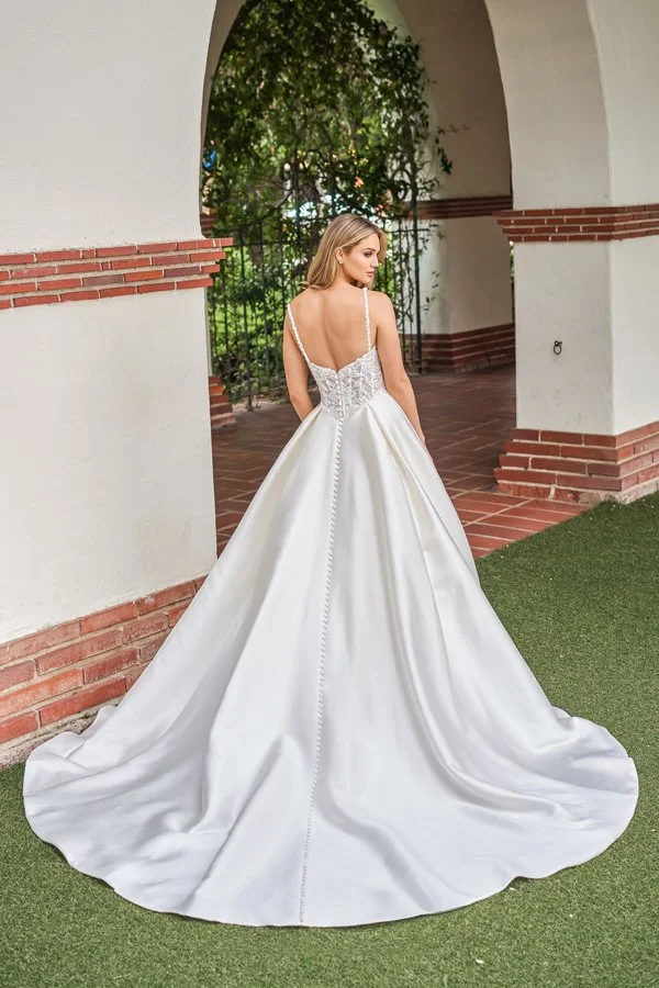 Back view of a satin A-line wedding dress featuring a floral lace illusion bodice, delicate spaghetti straps, a low V-back, elegant covered buttons, and a sweeping train for a timeless, romantic bridal look.