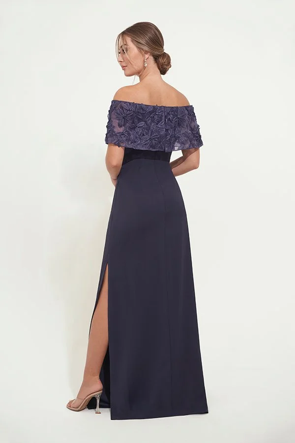 Back view of an elegant navy mother of the bride gown with an off-the-shoulder floral appliqué neckline, fitted silhouette, and side slit, perfect for weddings and formal events.