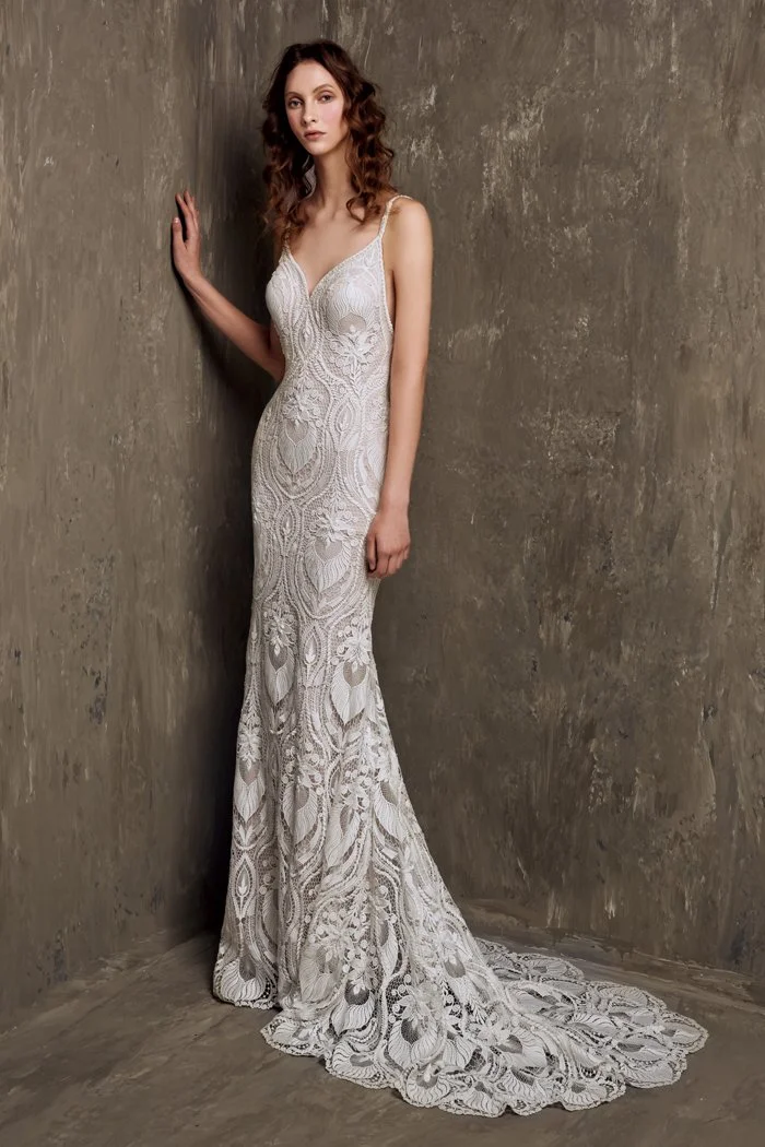 Bride in a fit and flare lace wedding dress featuring spaghetti straps, a plunging V-neckline, intricate botanical lace, and a chapel train, creating a timeless and elegant modern bridal look.