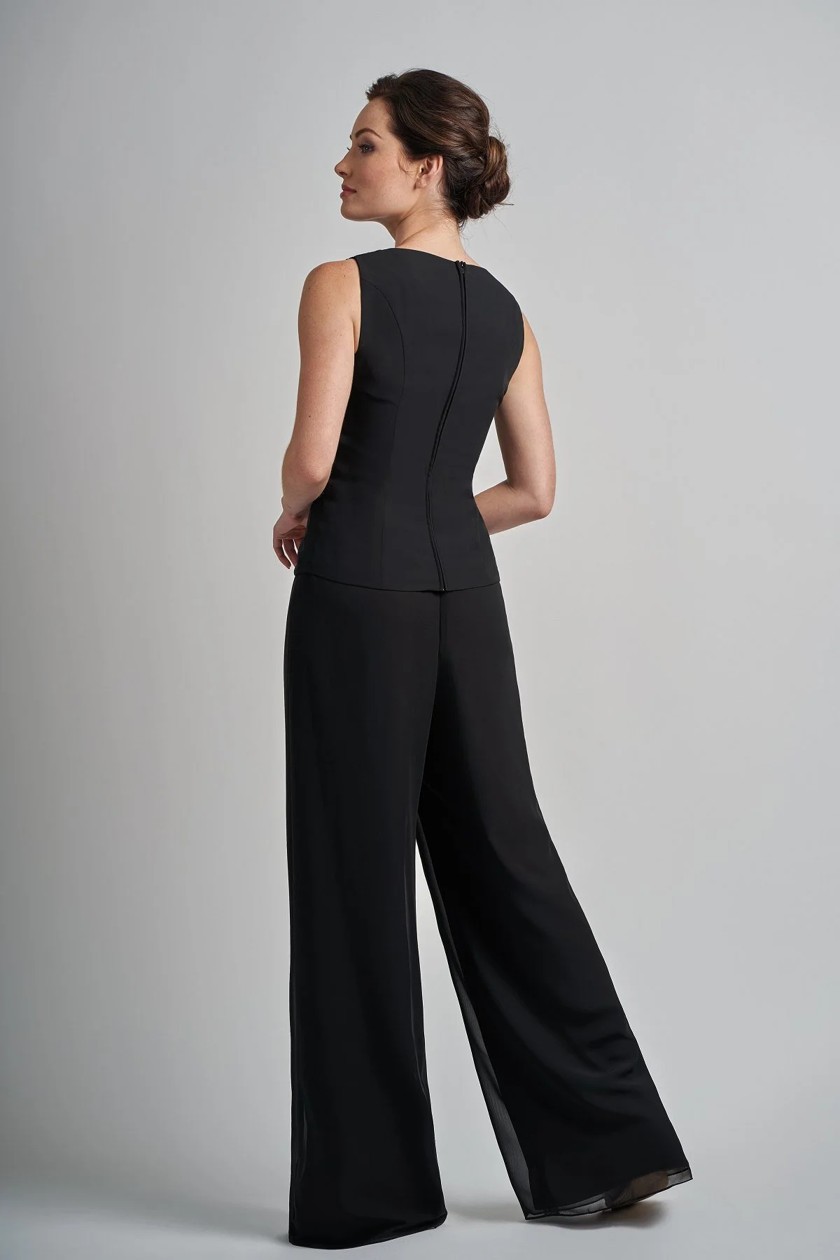 Back view of a black mother of the bride outfit featuring wide-leg formal trousers and a sleeveless tailored top, designed for elegant special occasion wear.