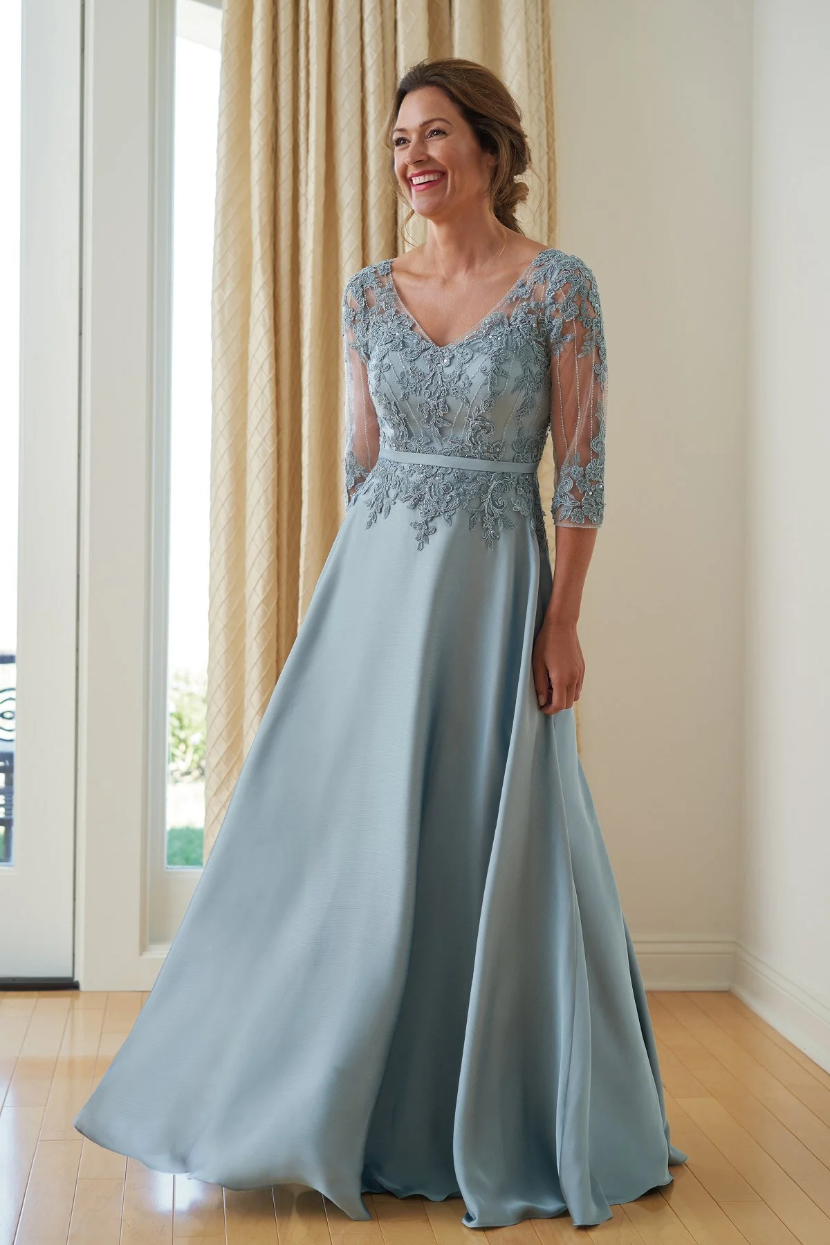 Front view of an ice blue mother of the bride gown with a lace embroidered bodice, illusion three-quarter sleeves, V-neckline, and a flowing A-line skirt for weddings and formal events.