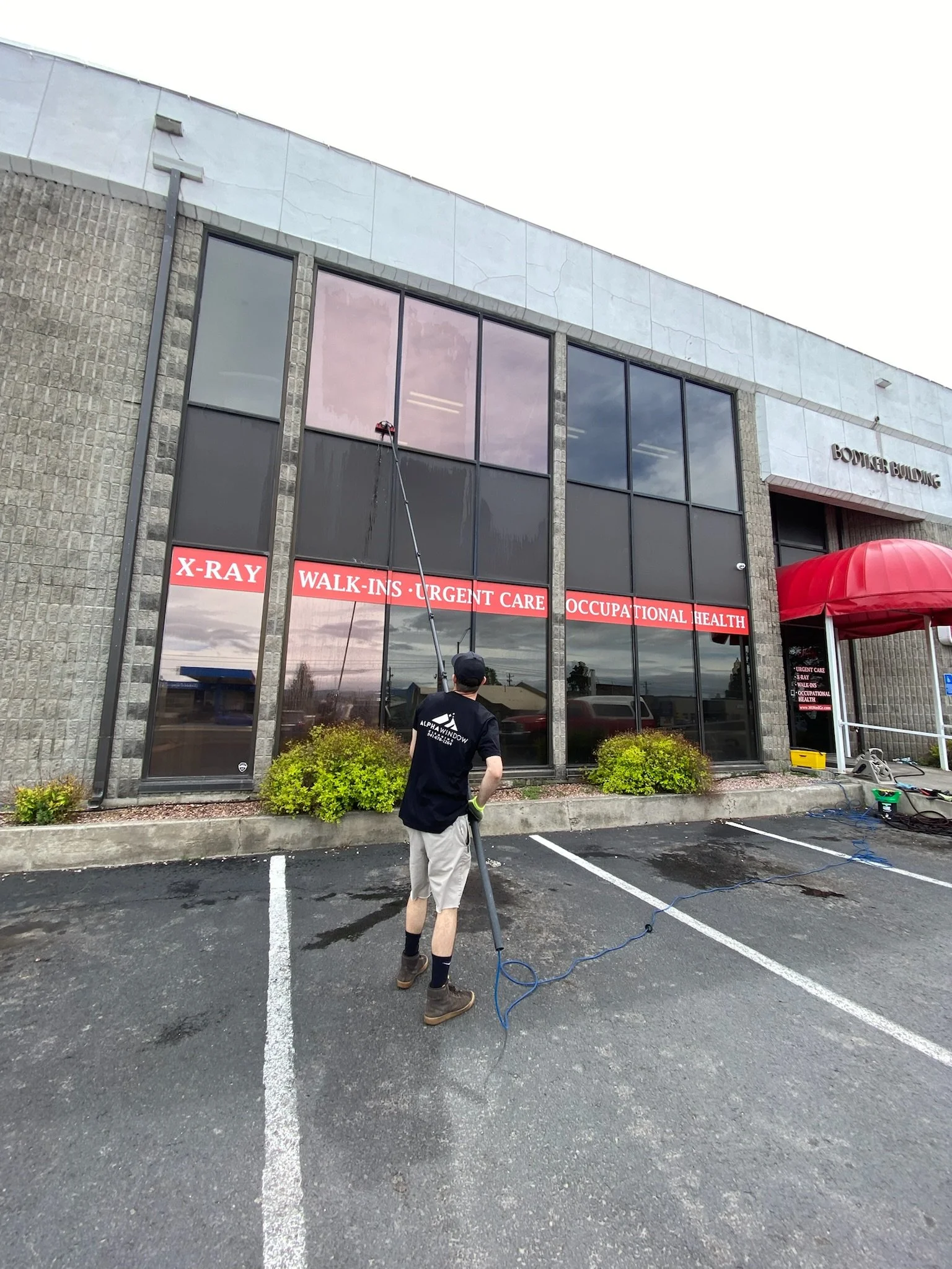 Cleaning the outside of mountain medical urgent care with a waterfed pole