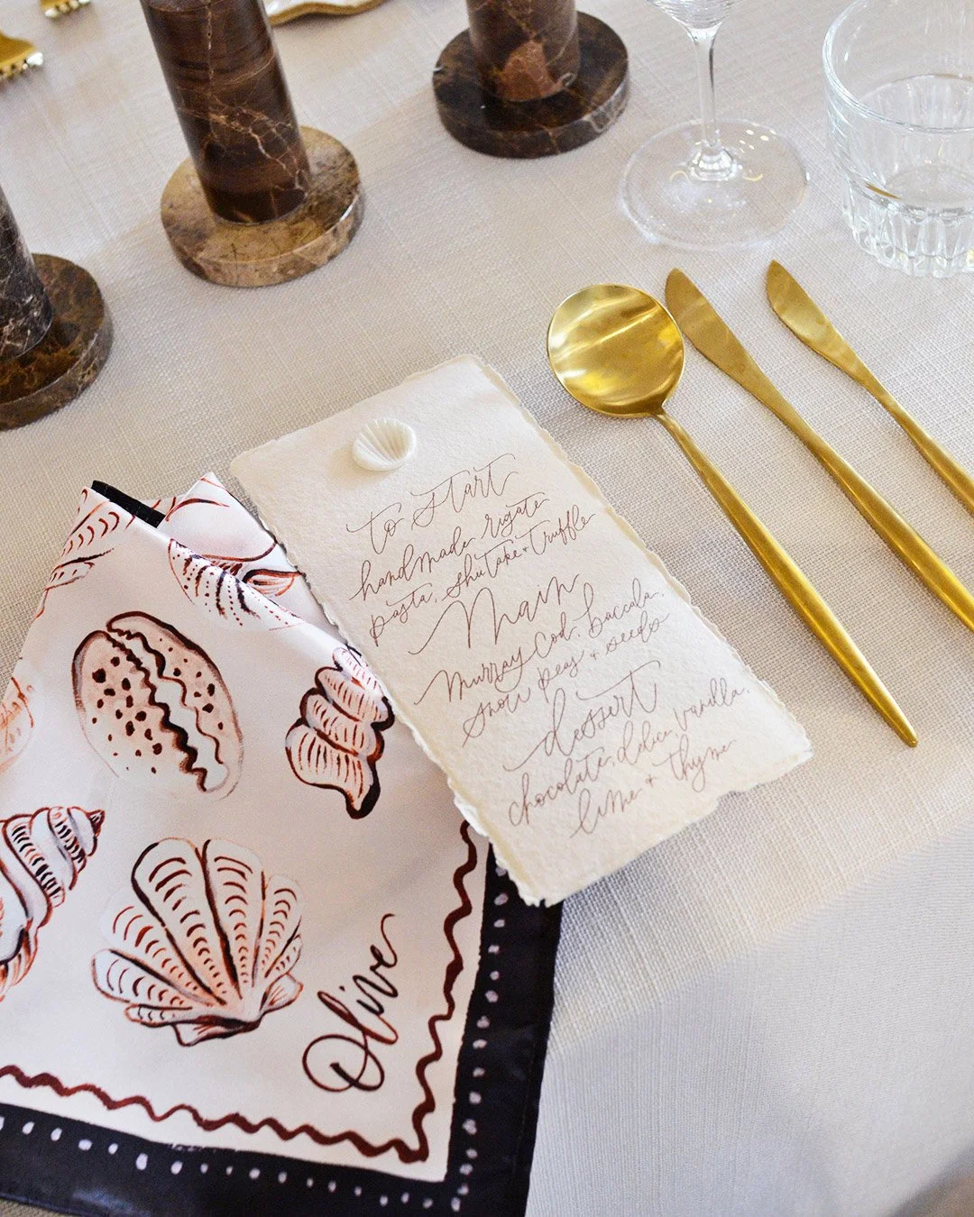 elevated-beach-wedding-theme-styling-menu-illustrated-seashell-napkin.jpg
