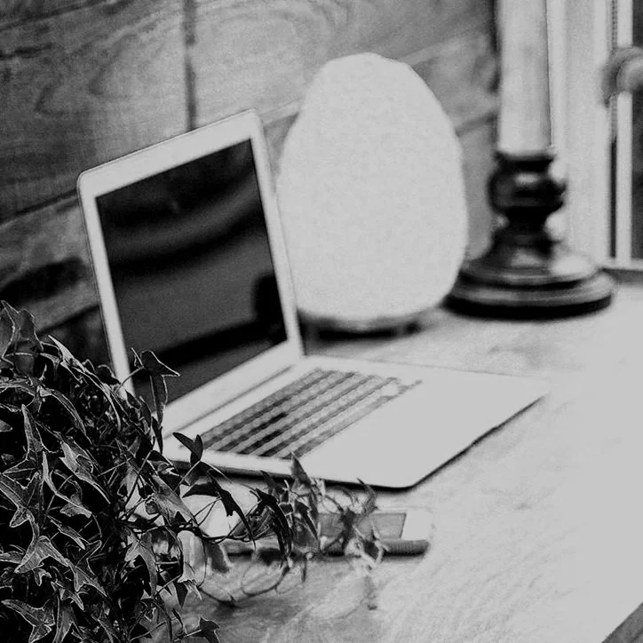 computer on desk next to salt lamp