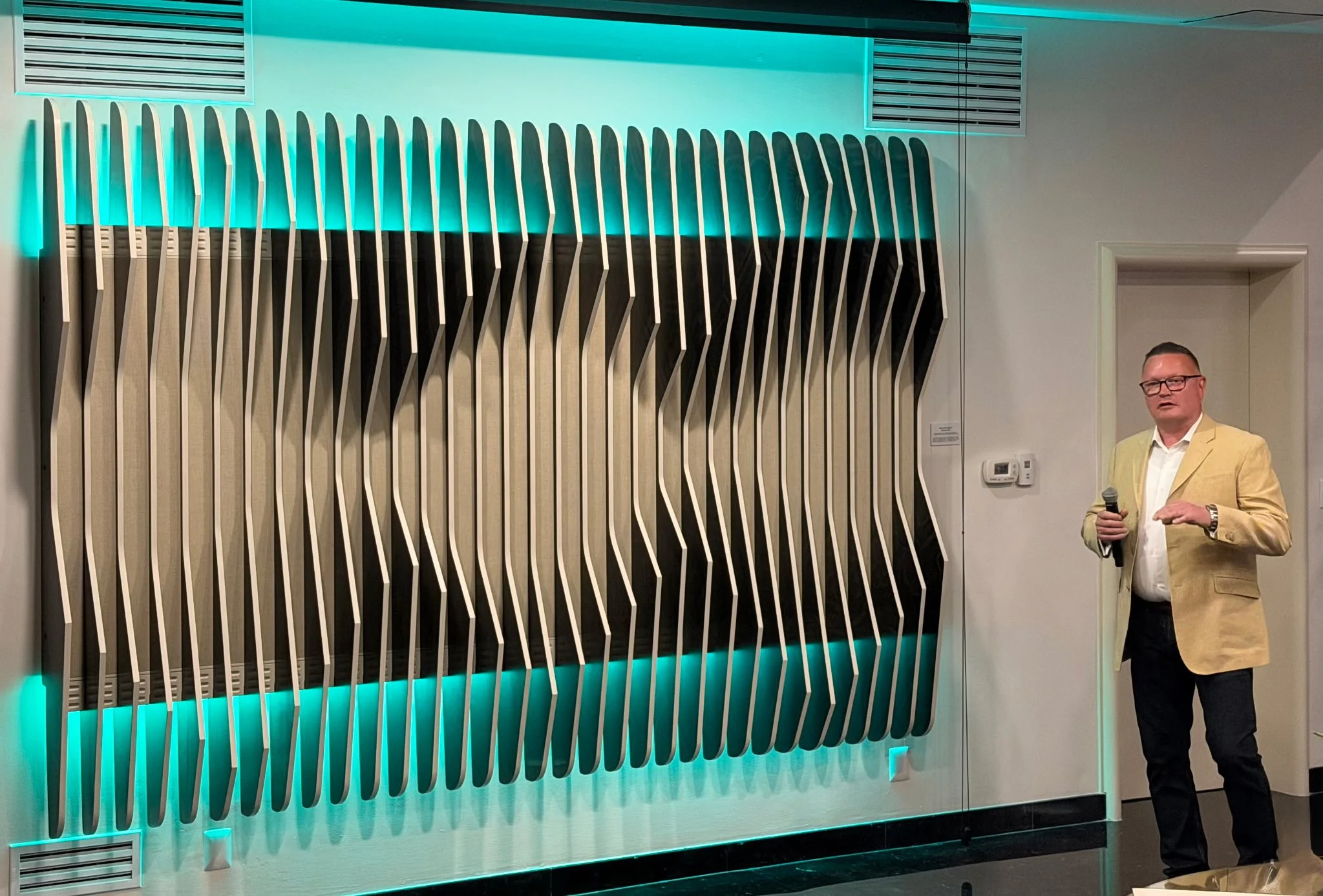 Rob Waissi stands to the right of Sculptura (eminating teal light) introducing the installation to the gathering at the US Consular Residence in Mexico City.