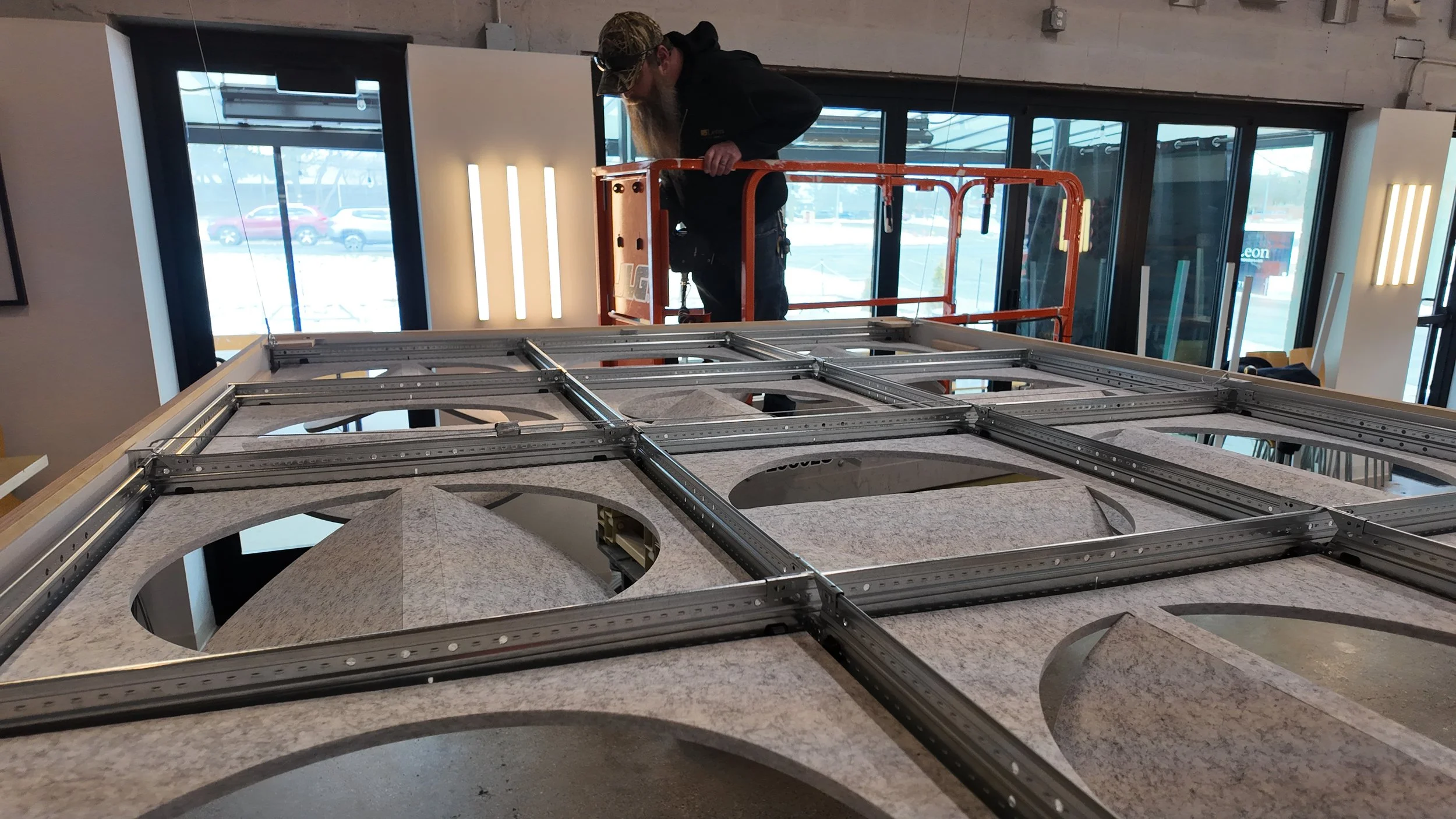 A man works on installing the Leon x Askia Acoustic Island inside the Mothfire Taproom