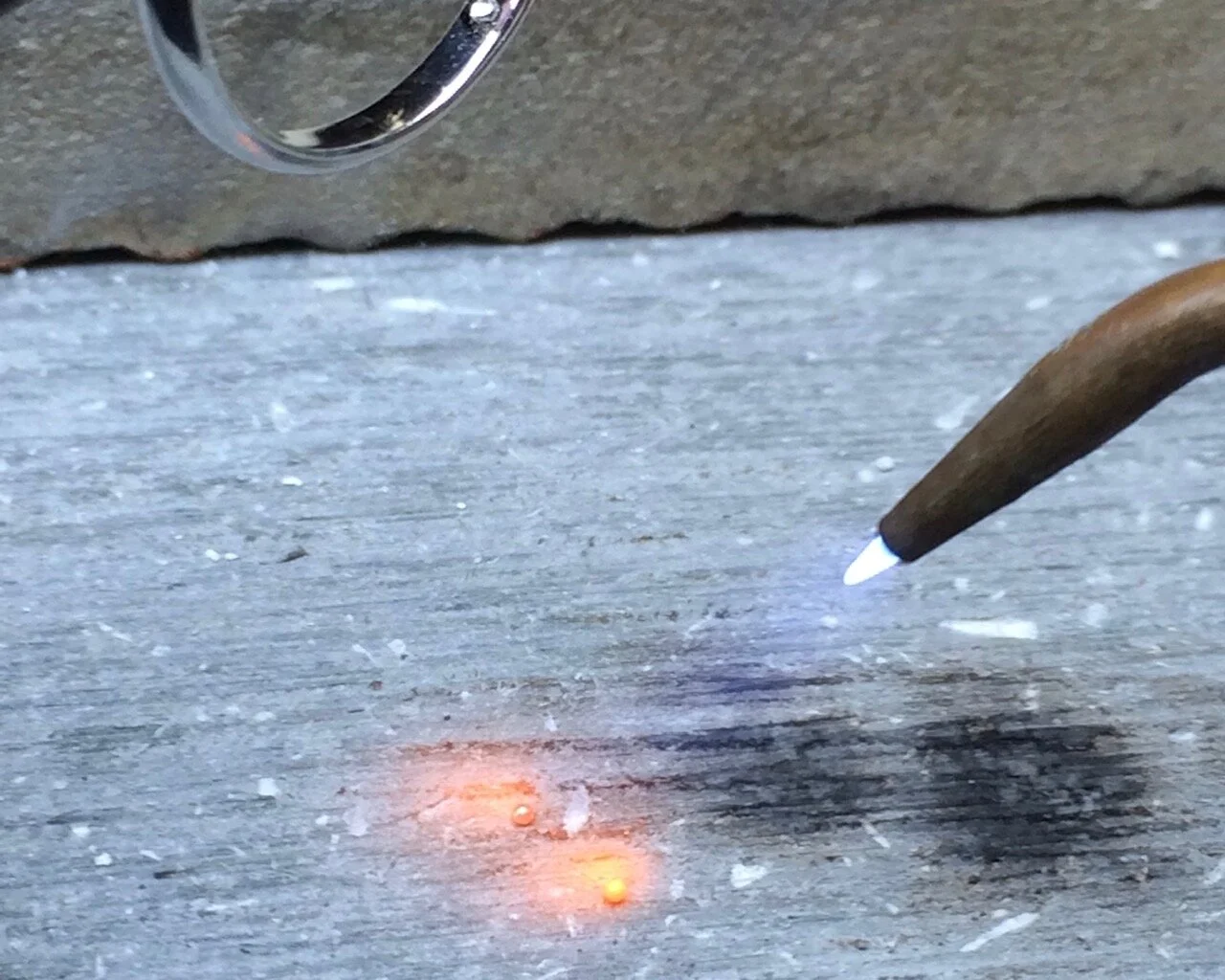 The strips of solder are heated, and they form into tiny balls.
