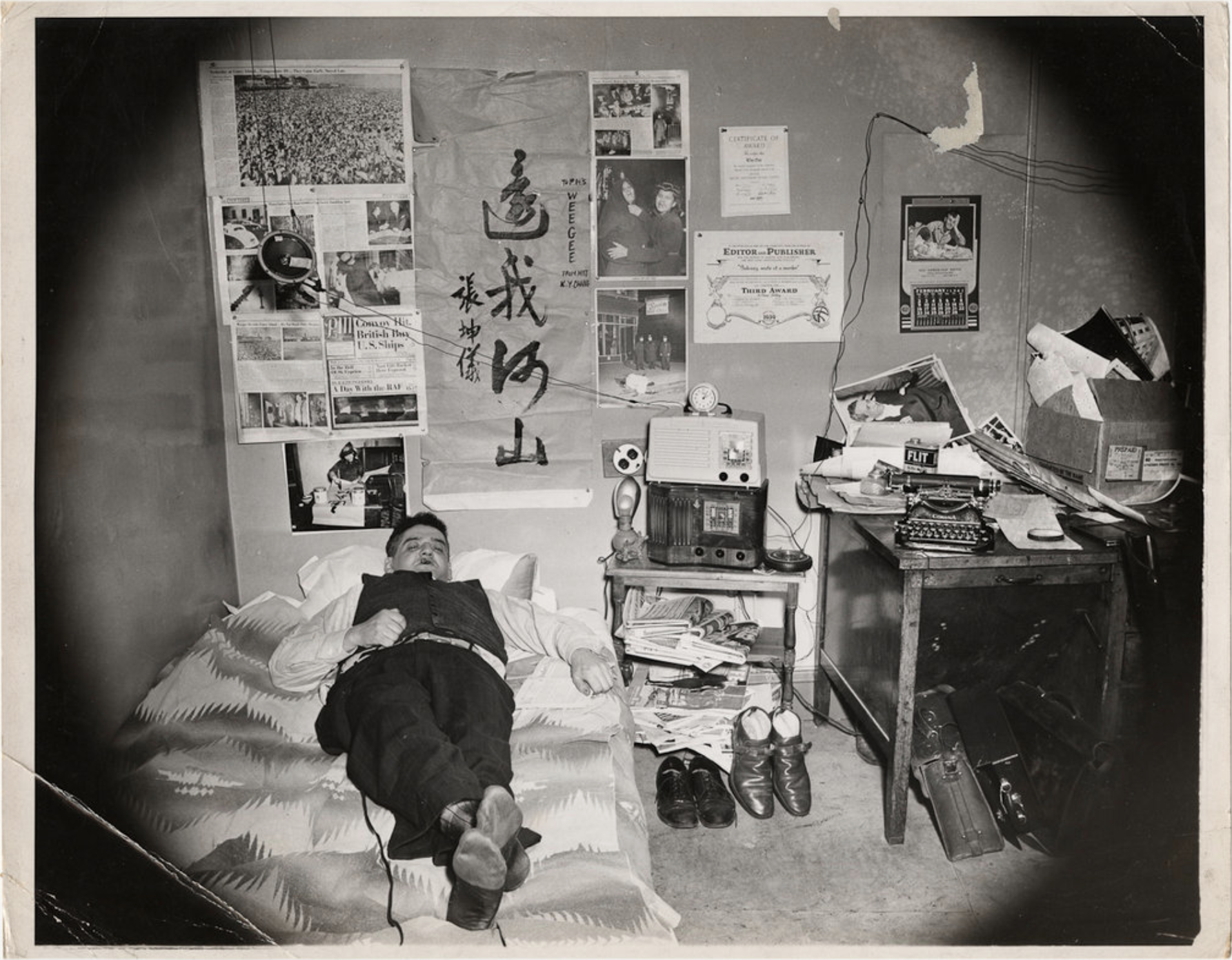 A self-portrait of Weegee in his bedroom, c. 1937. This and another similar photo served as inspiration for the bedroom recreation featured in the exhibit.