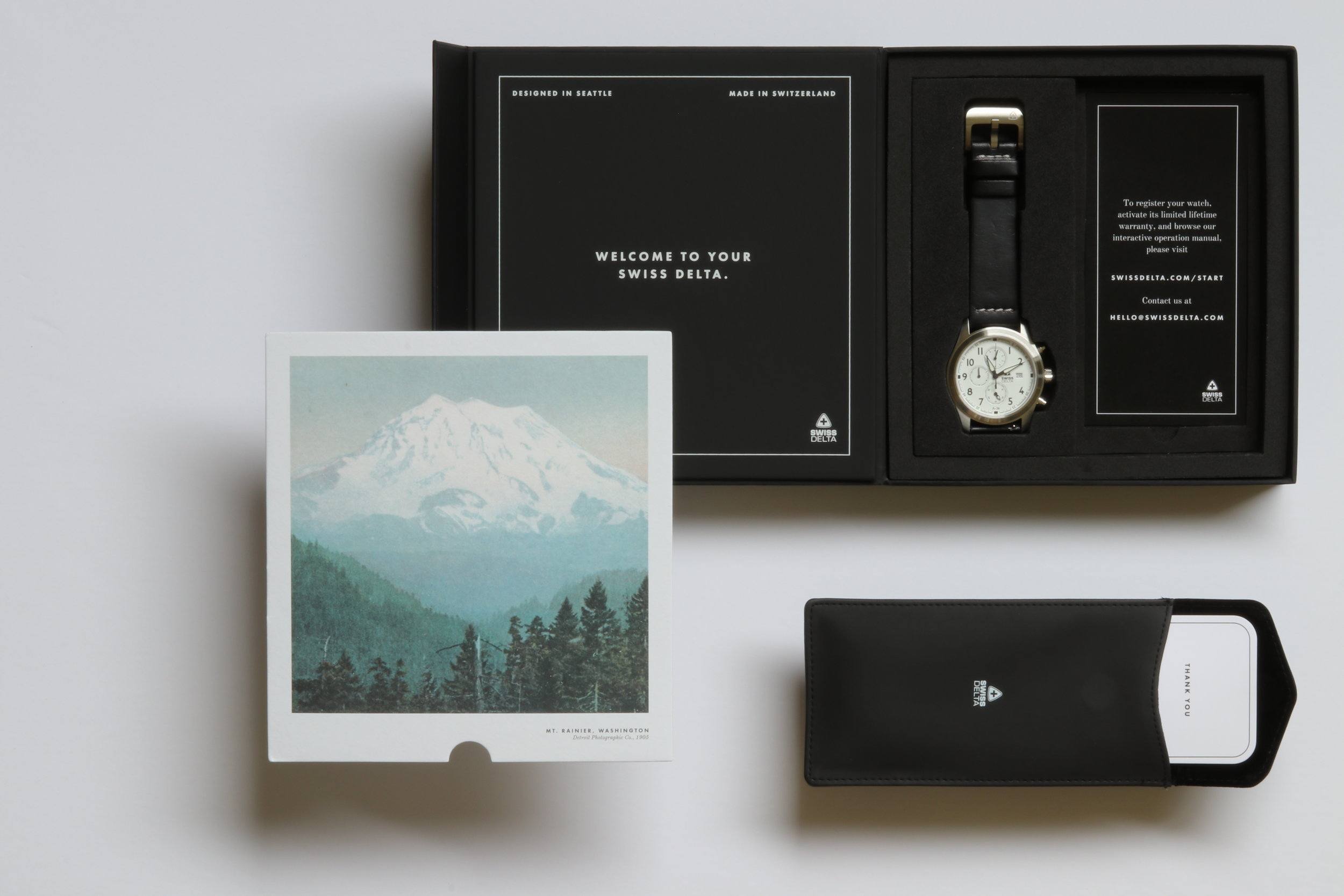Swiss Delta packaging, including an insert of Mt. Rainier, a travel pouch, and an instructions card to register your watch and access our interactive watch manual.