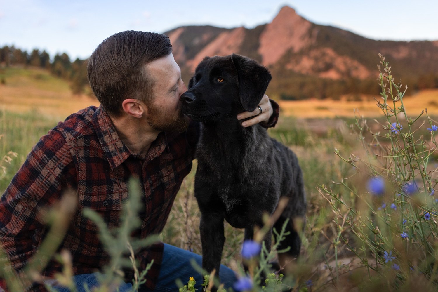 Dog owner snuggling with his dog during a photo session in Boulder's Chautauqua Park.