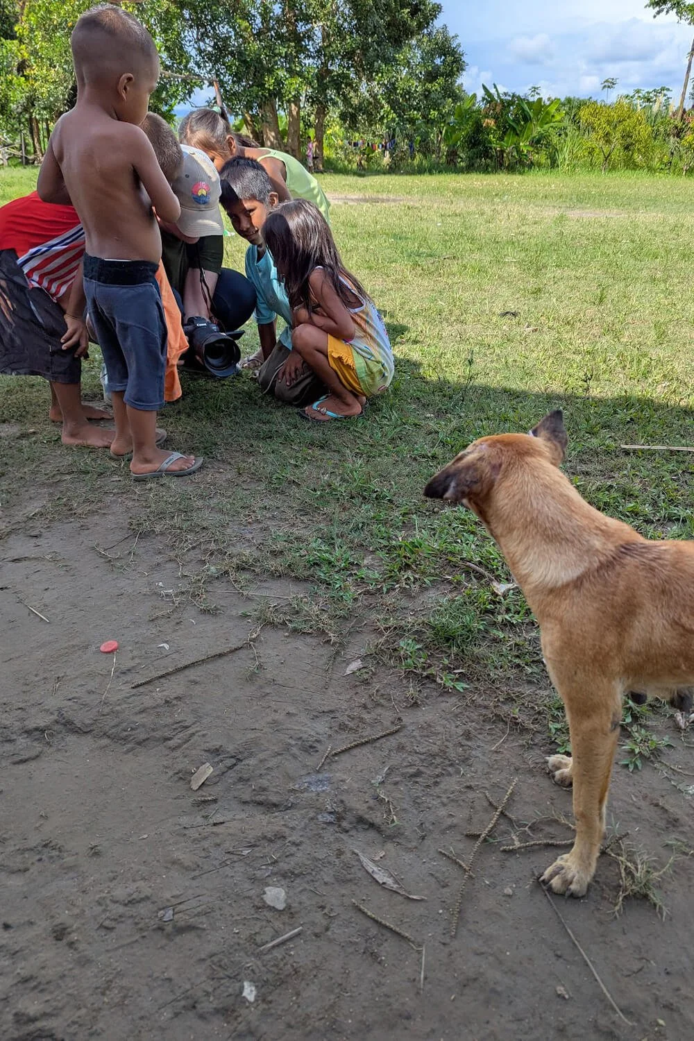 Allison Mae sharing her camera with curious children in the Colombian Amazon, reflecting her warm, patient, and connected approach to photography.