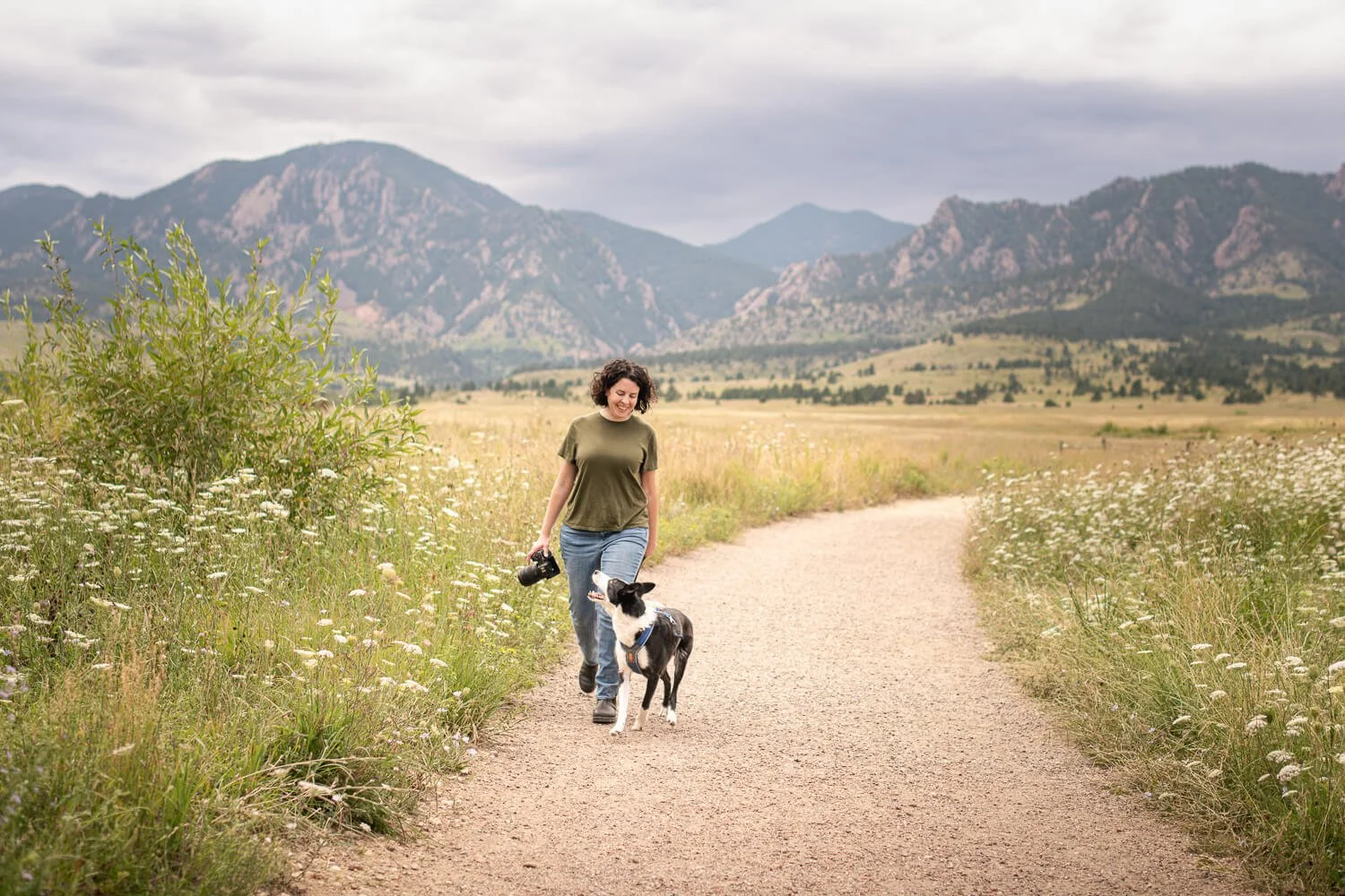 Denver dog photographer Allison Mae walking a high-energy dog on a mountain trail near the Boulder Flatirons during a summer adventure session