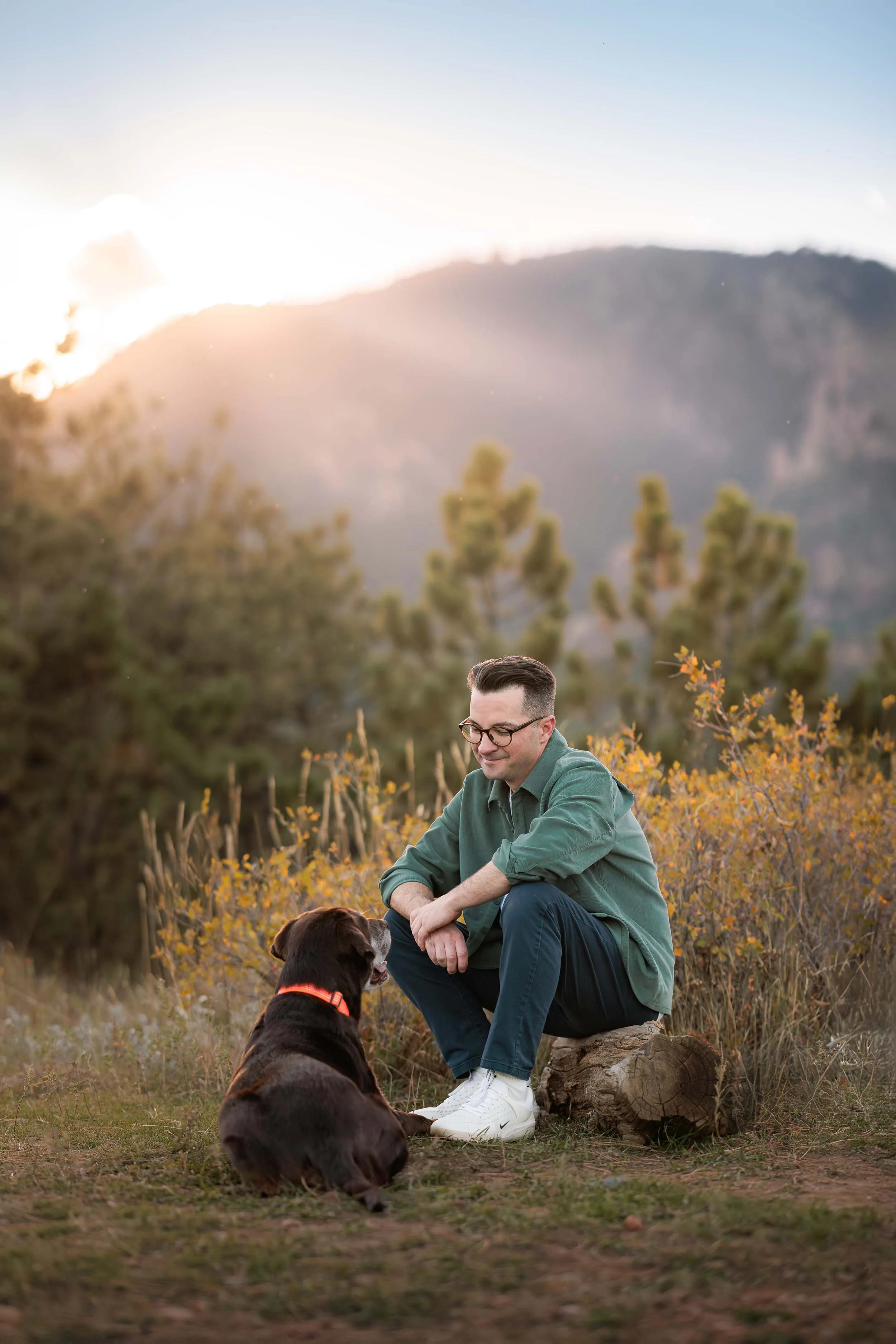 A dog and his owner share a special moment while relaxing on a trail in the Boulder Flatirons.