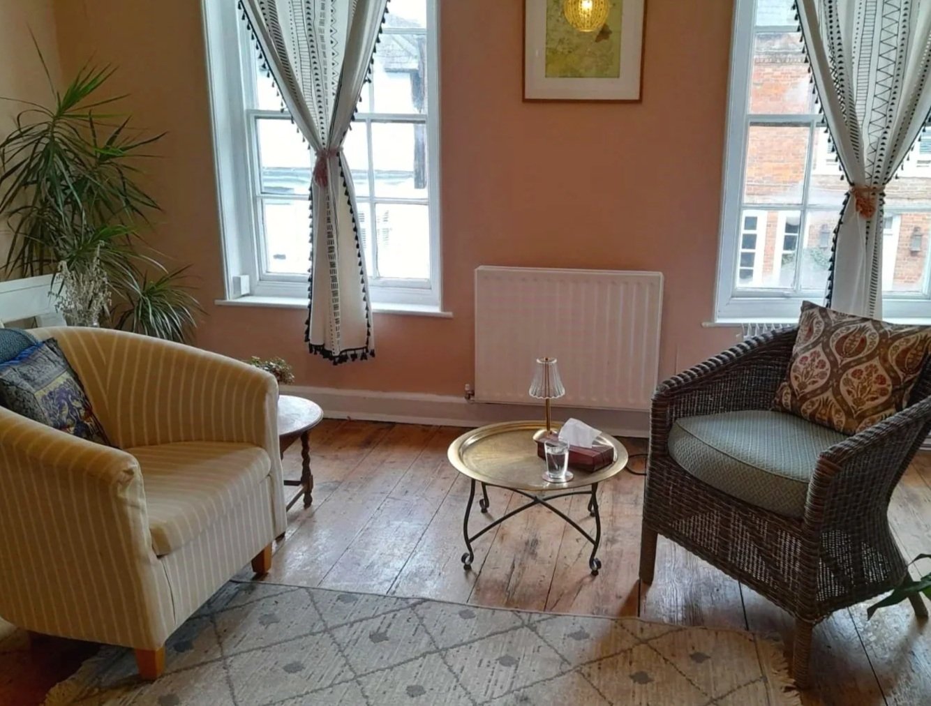 A calming counselling space in Steyning with two chairs.  Natural light comes in through floor to ceiling windows.