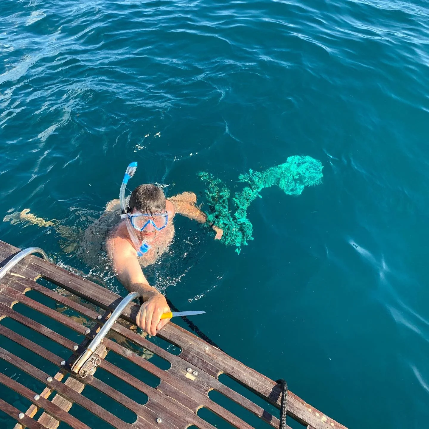 Captain Mike to the rescue! We just had a giant fishing net wrapped around our propeller and Mike had to jump in and cut it off. Never a dull moment!