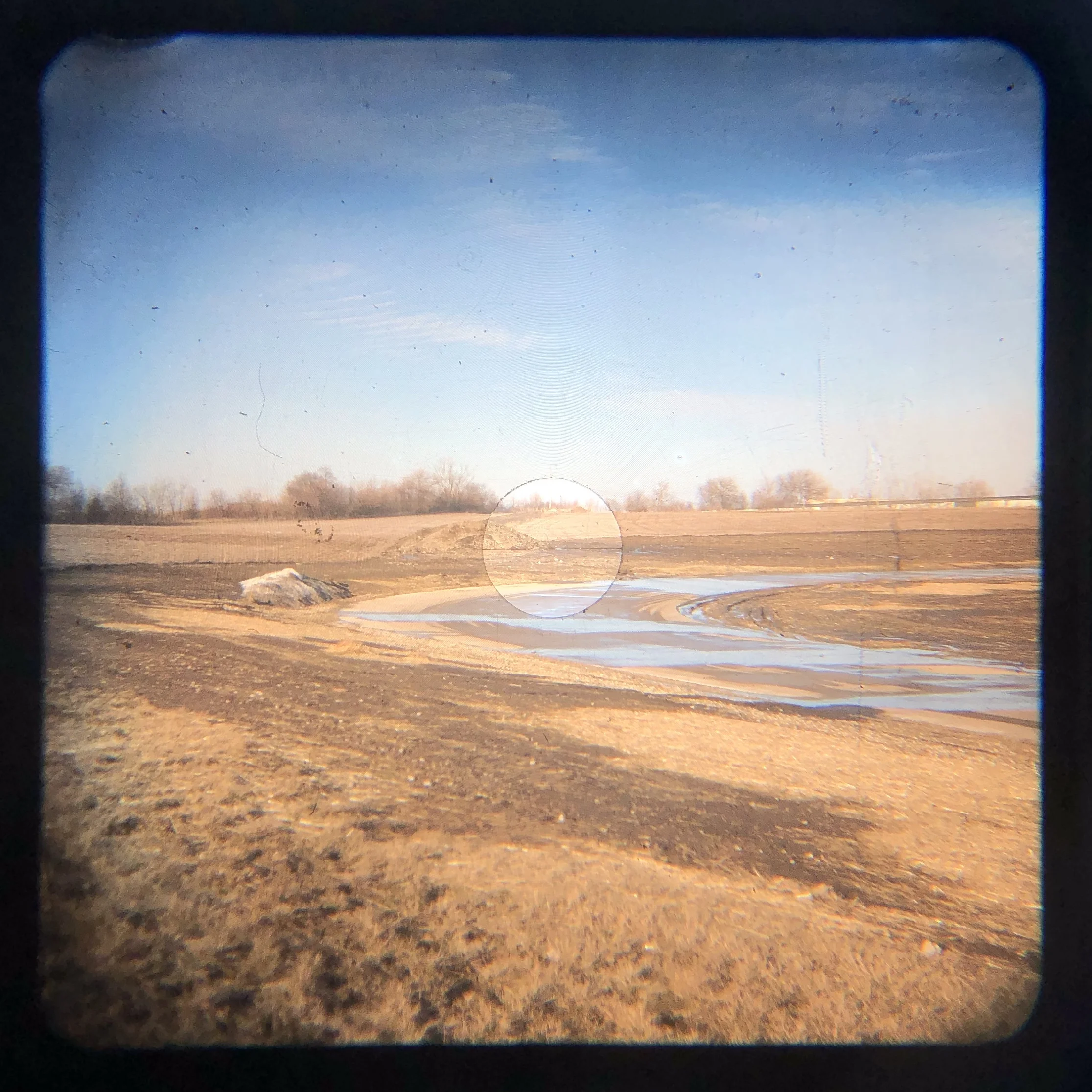 When walking up to the side of the road to make this image, I didn’t see the water on the paved utility road catching the light of the sky.
