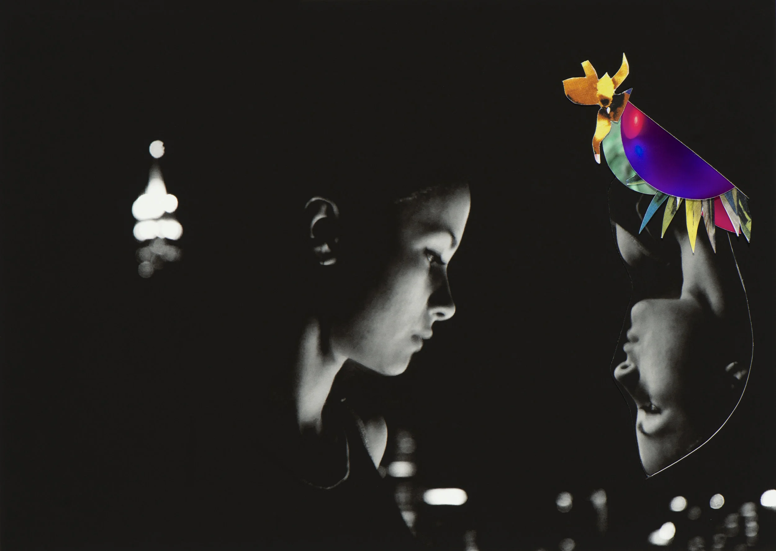 Black and white image of two children facing each other, with city lights in the background. One child is wearing a colorful, decorative headdress.