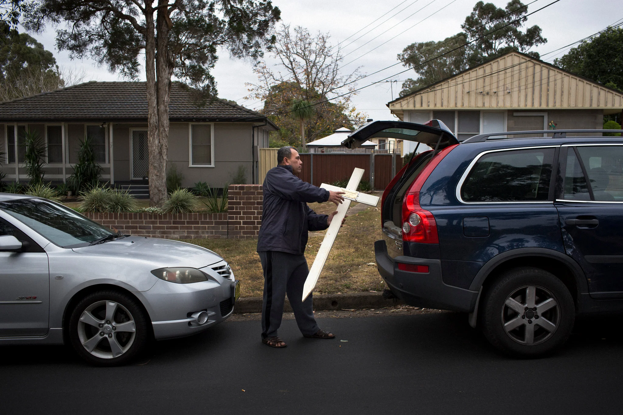 Vaea Togatuki after visiting the grave of his son Junior, who died in 2015 in an Australian prison, where he was being held by immigration officials after finishing his sentence. Because the Togatuki family is still paying off the cost of his tombstone, they take their own cross to the cemetery. Credit: David Maurice Smith for The New York Times