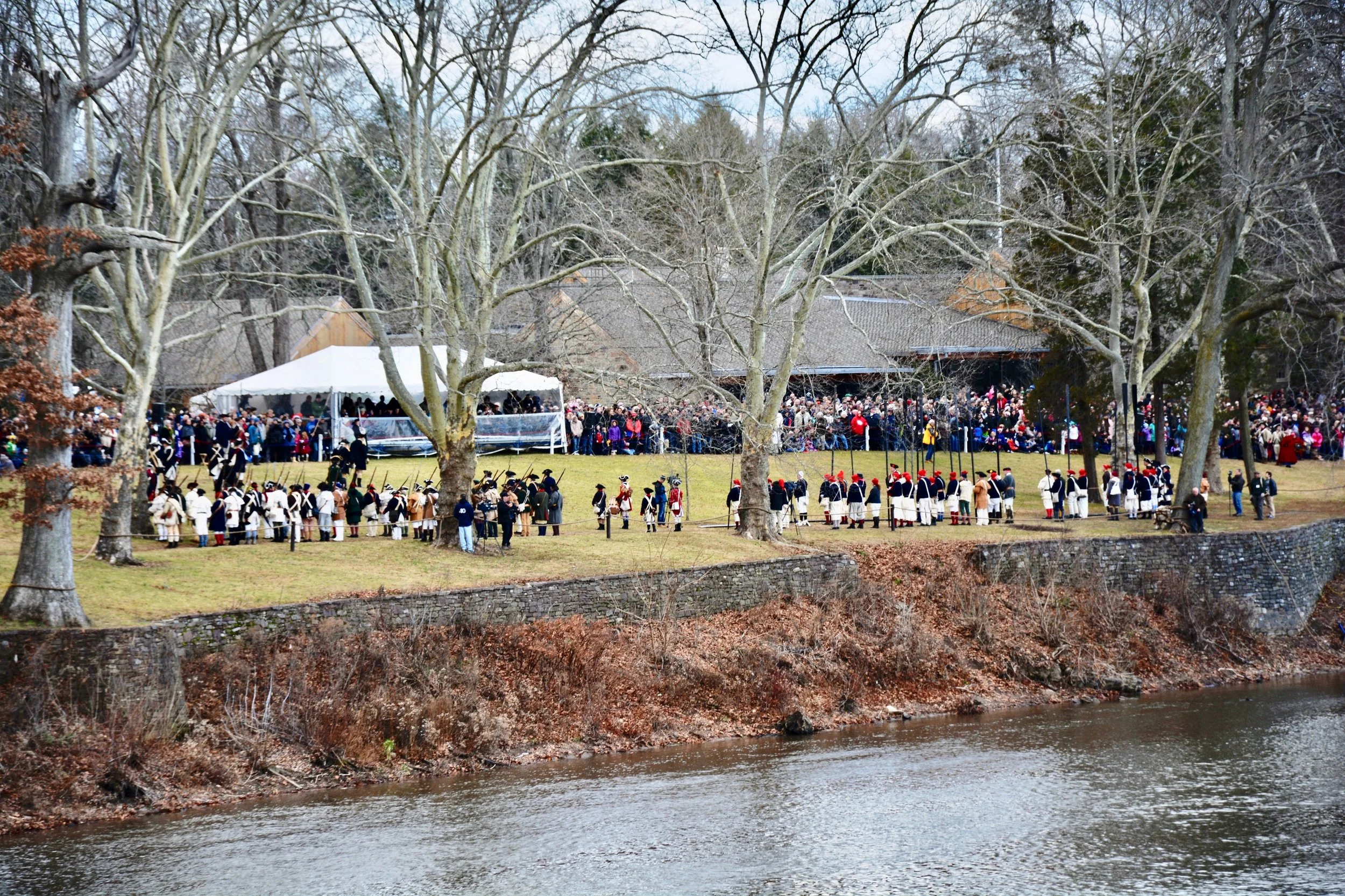 Spectators gather on the banks of the Delaware river to view the reenactment.