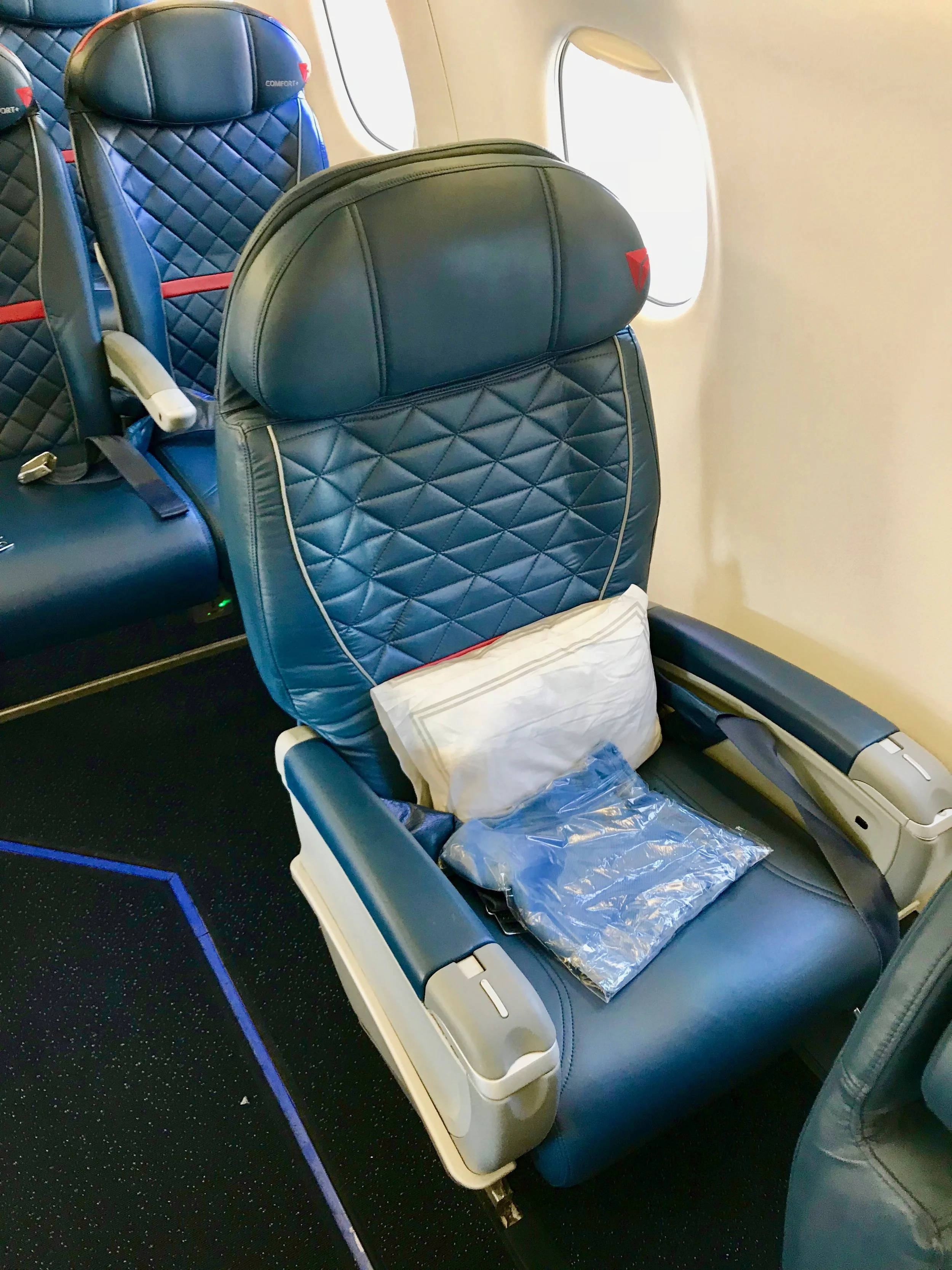 Seat 5B is directly behind the last single-seat in First Class (pictured). Seat 5B has additional legroom due to the position of seat 4A. There is a power outlet under the seat.
