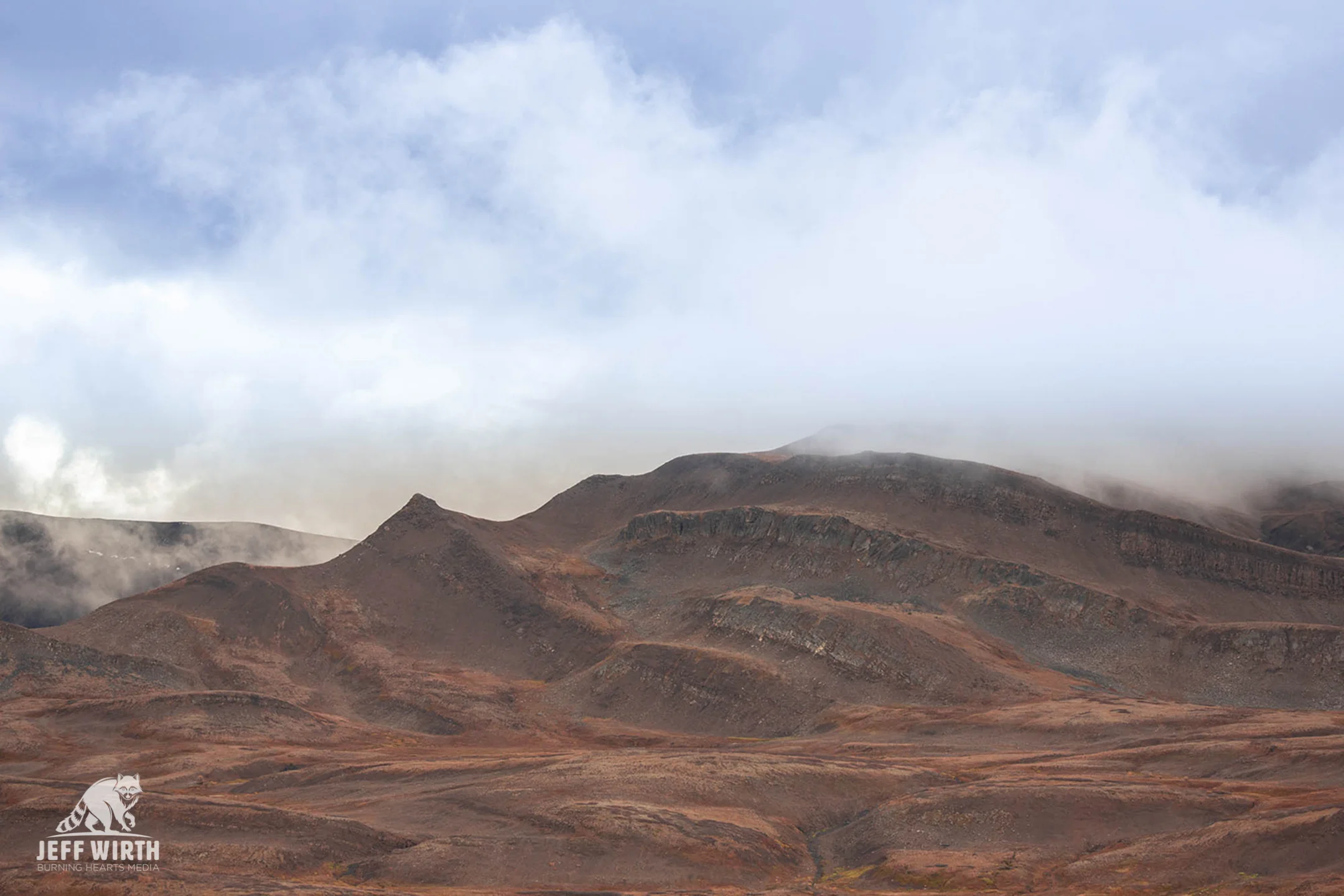 Red rolling hills seen from the high altitude summit of Klappan mountain. Sacred Headwaters, BC, Canada