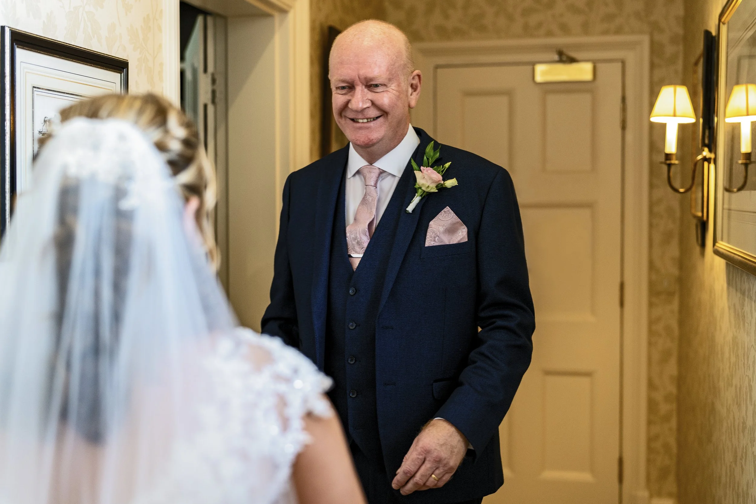 Father of the bride seeing his daughter in her wedding dress for the first time