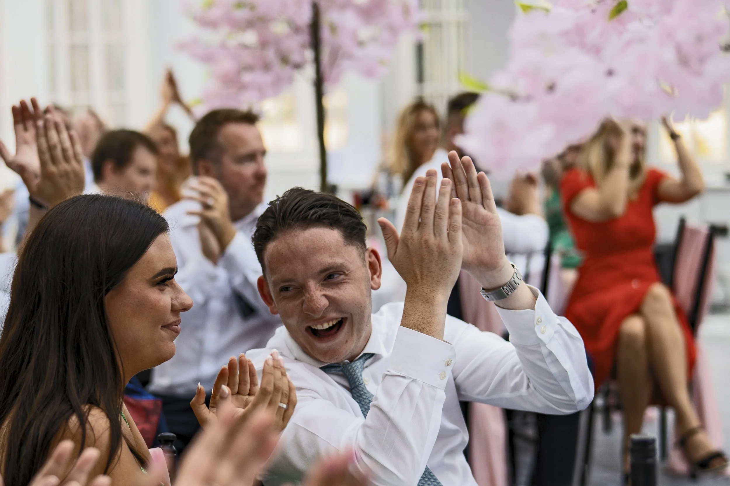 Wedding guests clapping and smiling at the reception