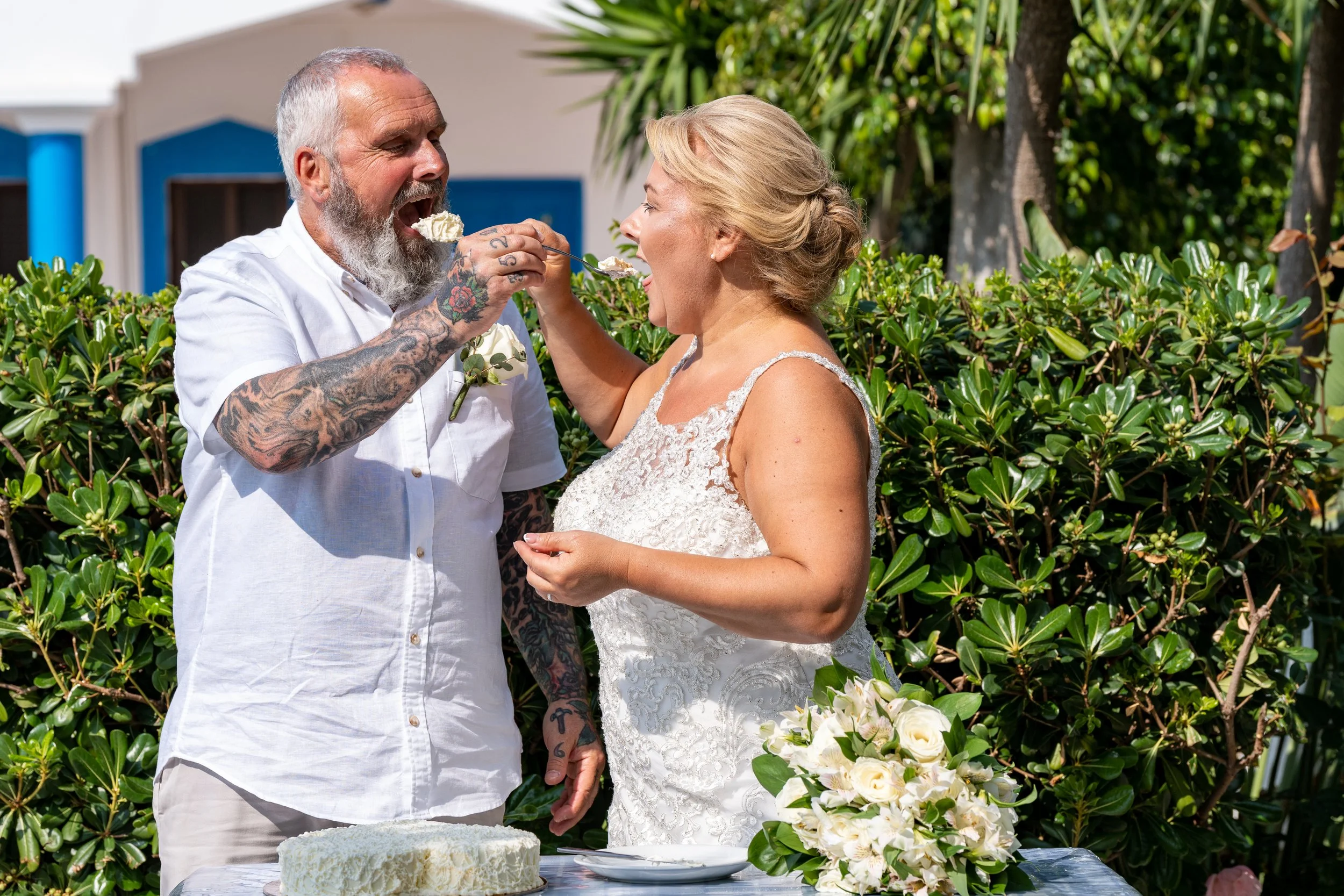 A couple getting feeding each other cake after a ceremony abroad in Greece