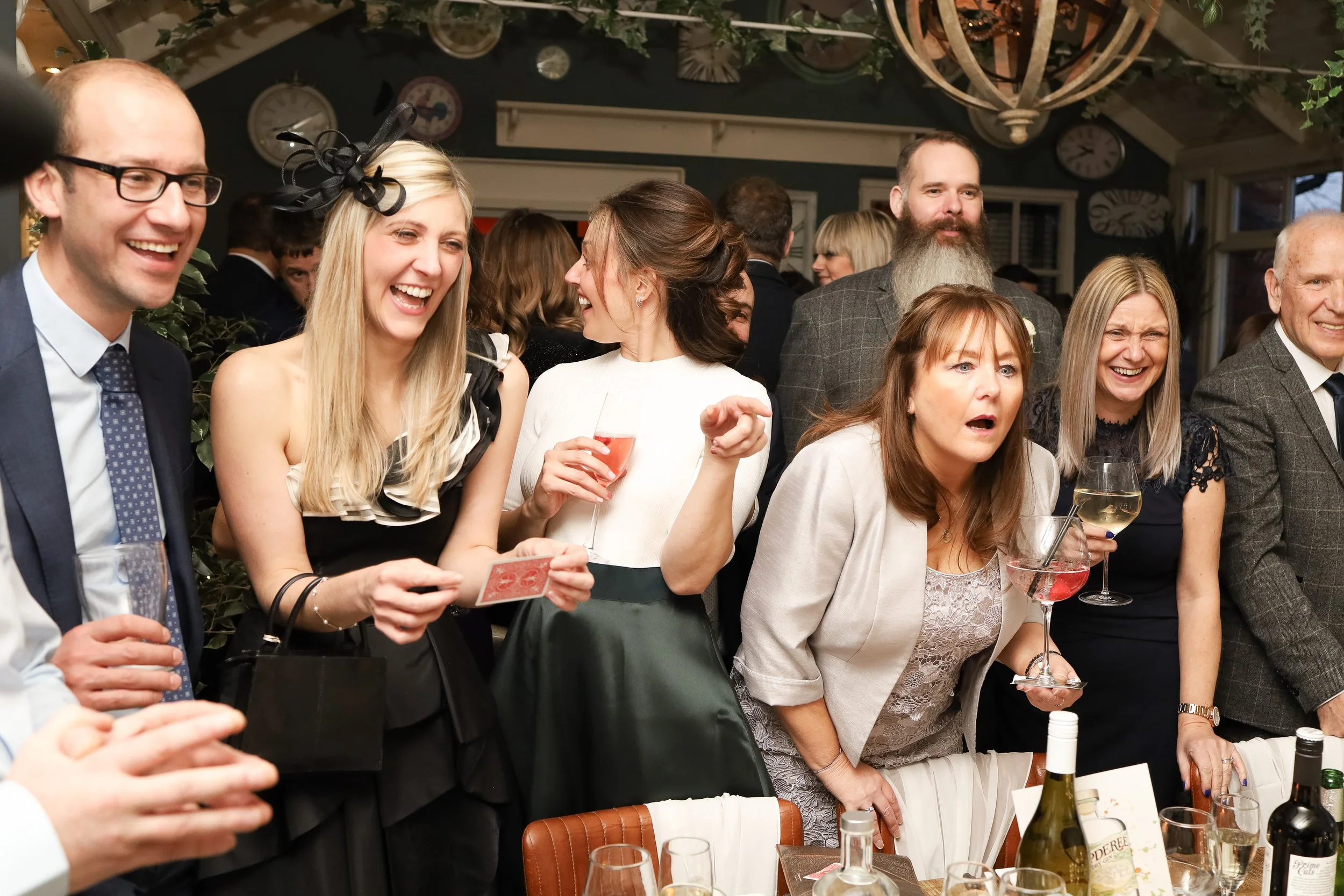 Wedding guests laughing and enjoying the entertainment at the reception