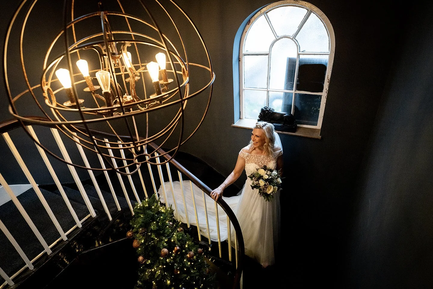A smiling bride walking down the stairs on the way to the ceremony
