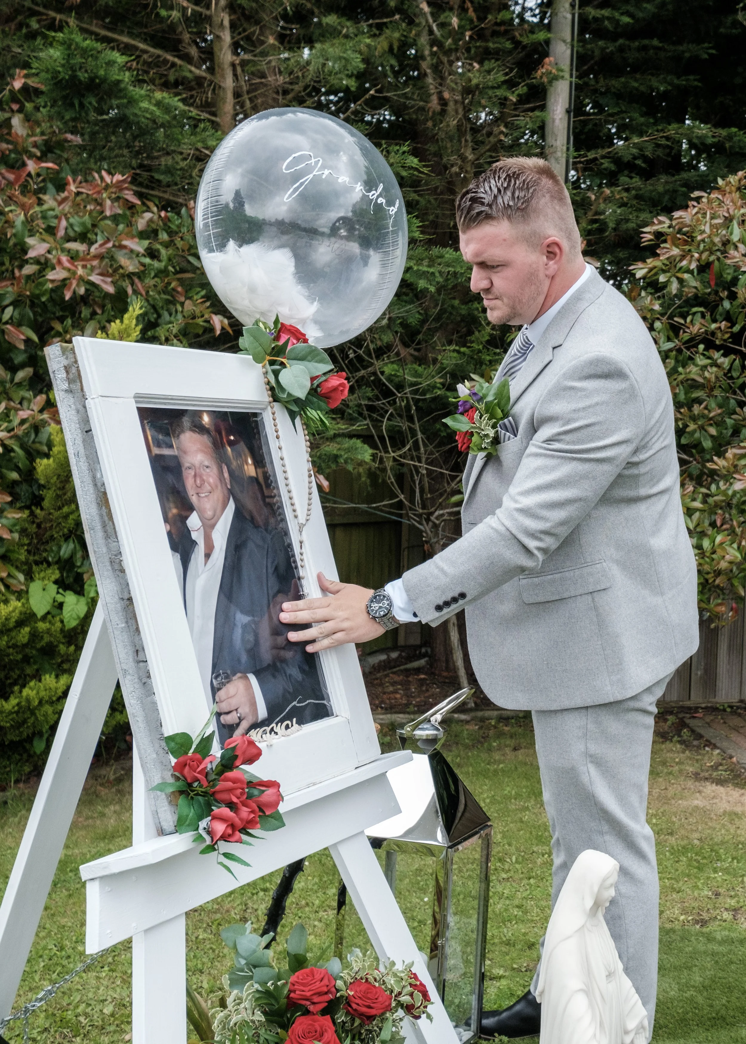 The groom photographed in a candid documentary style before his wedding paying tribute to his father