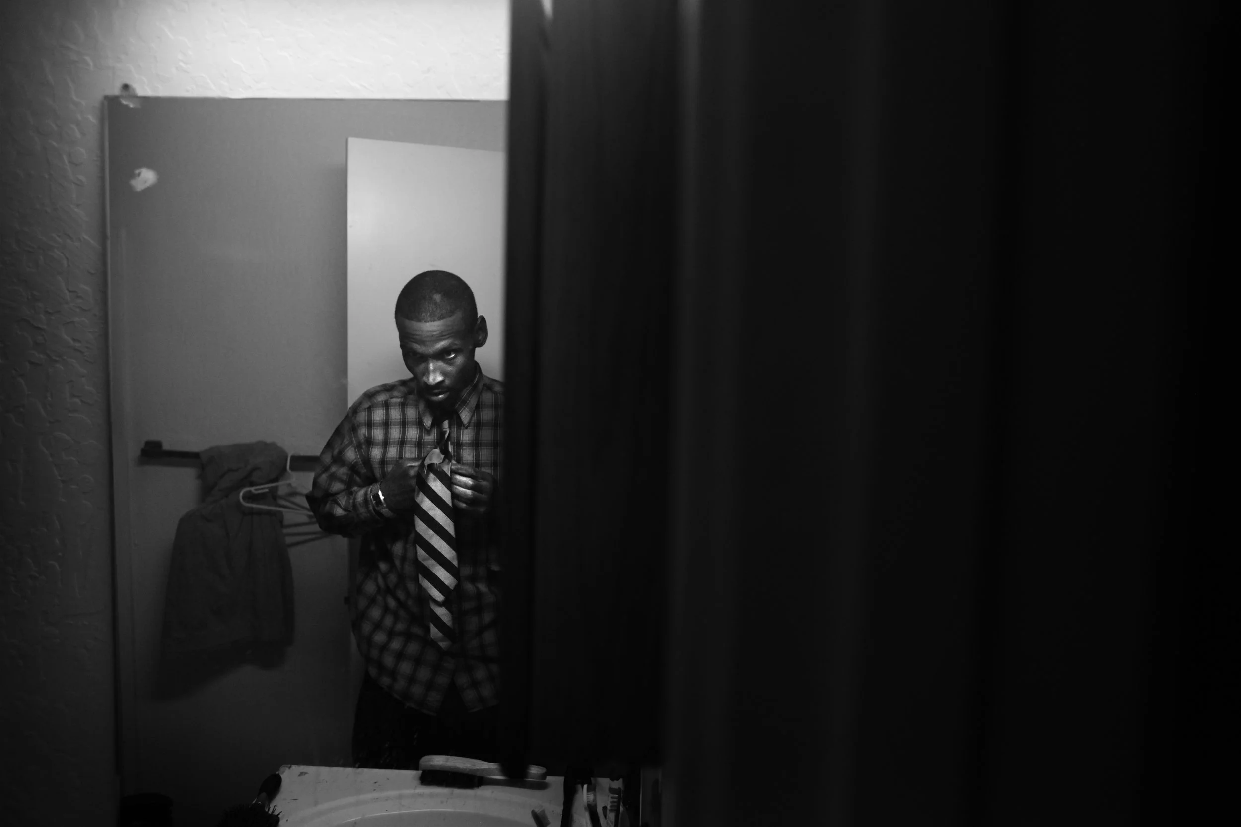  Shanon tries on a tie in preparation for a job interview in downtown Oakland. 