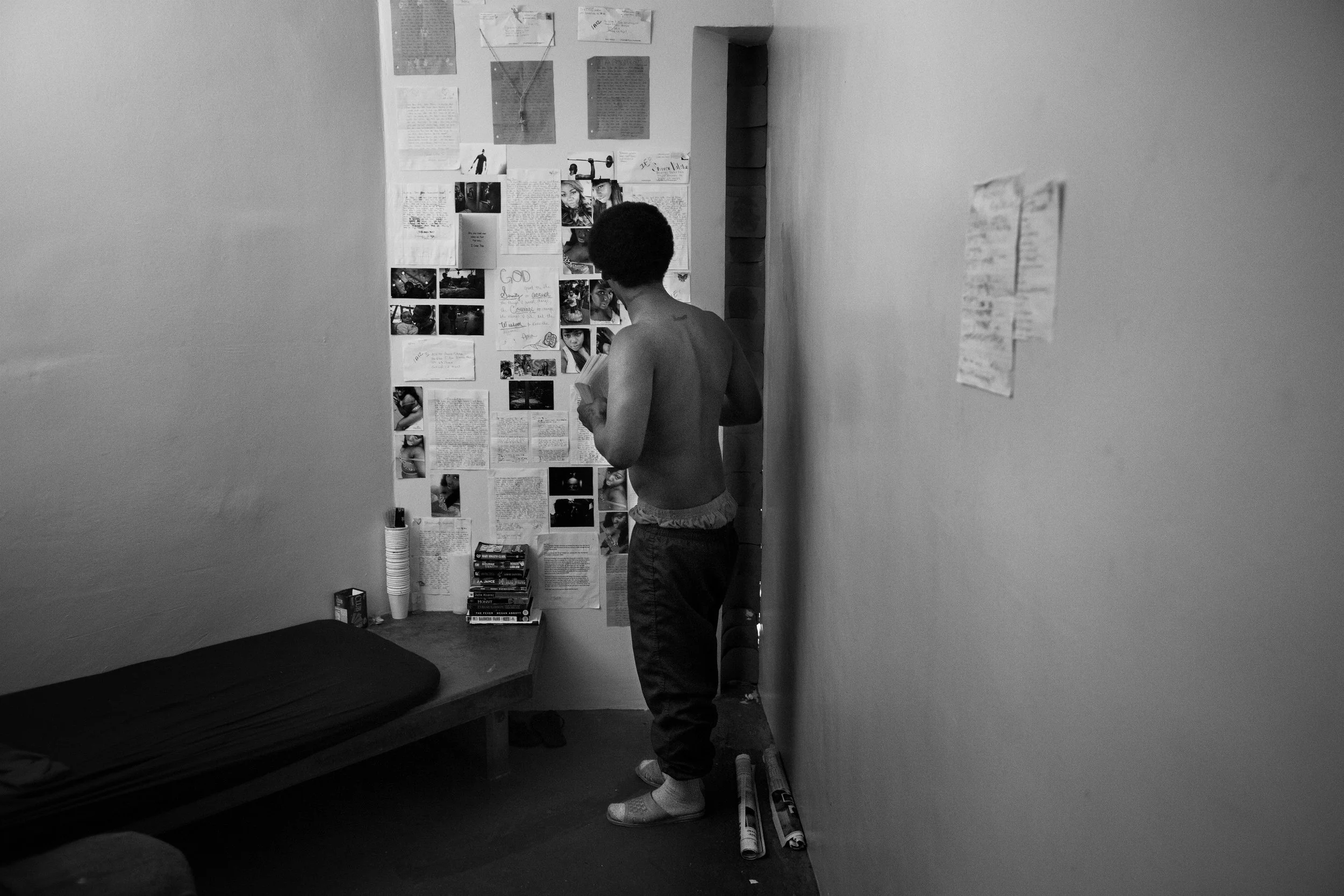  Shanon looks at letters and photos sent from friends hung on the wall of his jail cell at the Glen Dyer detention facility in downtown Oakland. 