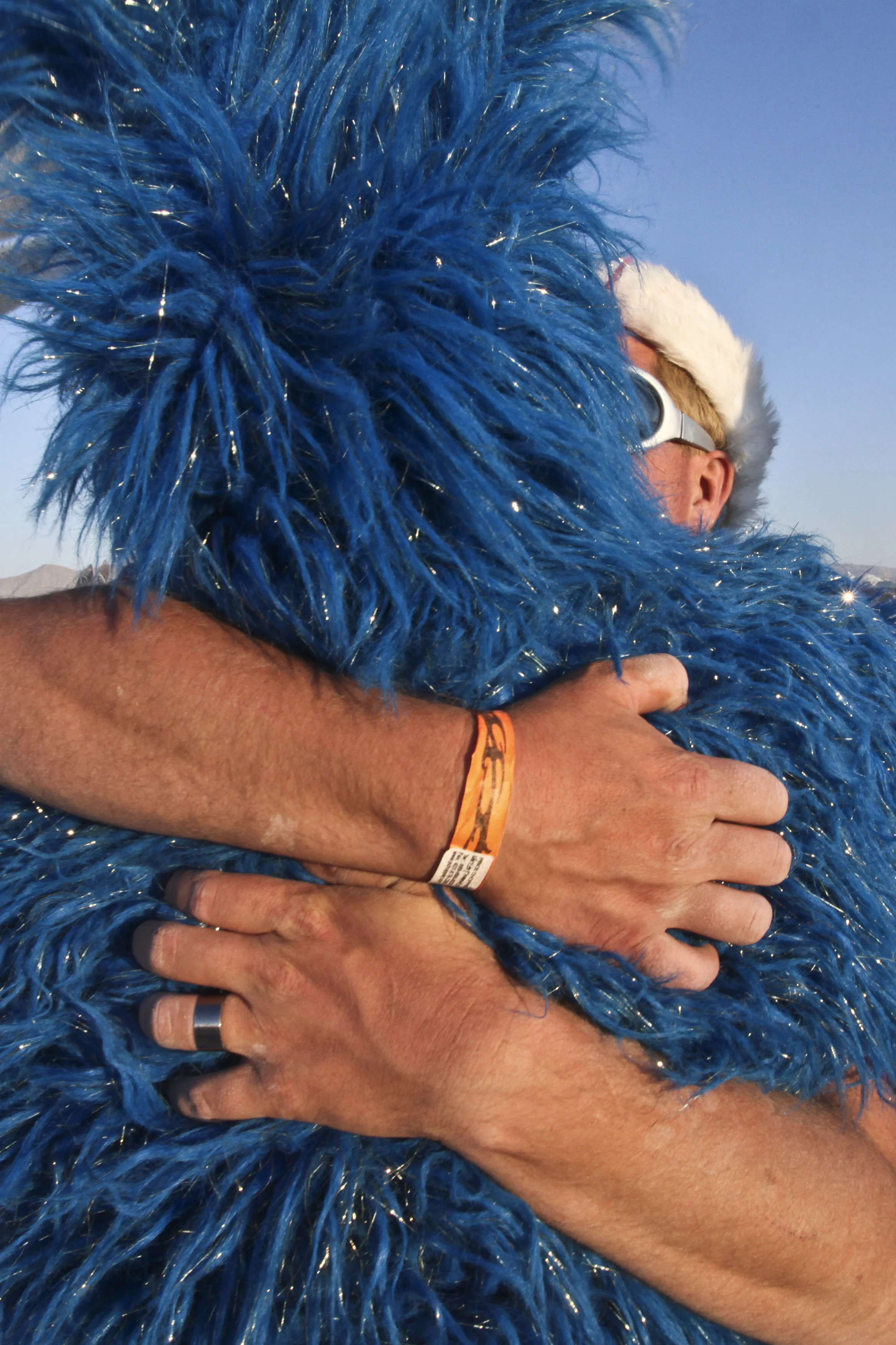  A man hugs a another man known as "fuzzy bunny". Fuzzy bunny wears this blue bunny costume for the course of the week. 
