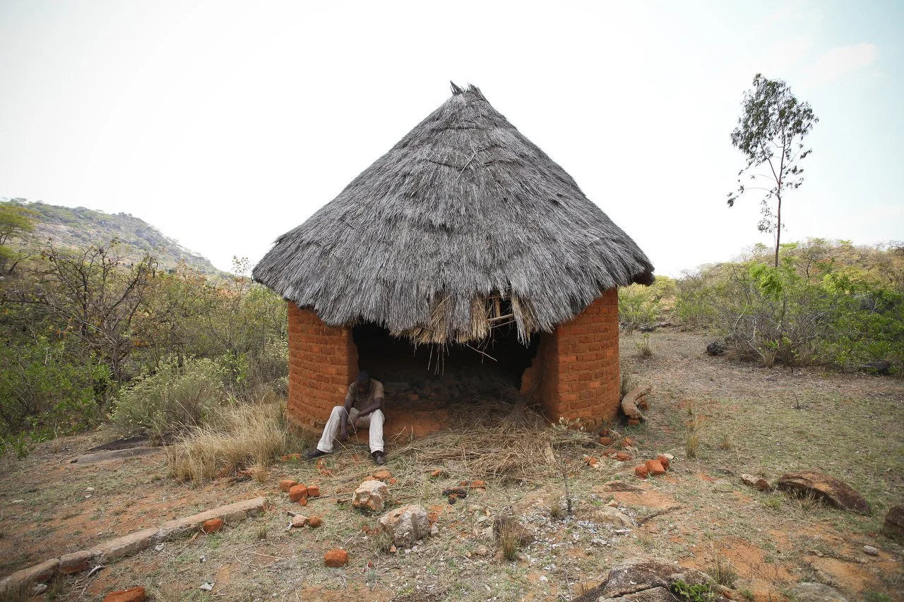  In his old village, now abandoned, Reymond Mapakata  sits in front of hut. His village is located in the region of Bakita in Zimbabwe. The village is about a 40 minute hike from the closest shops. Thousands of Zimbabwean refugees crossed the border 