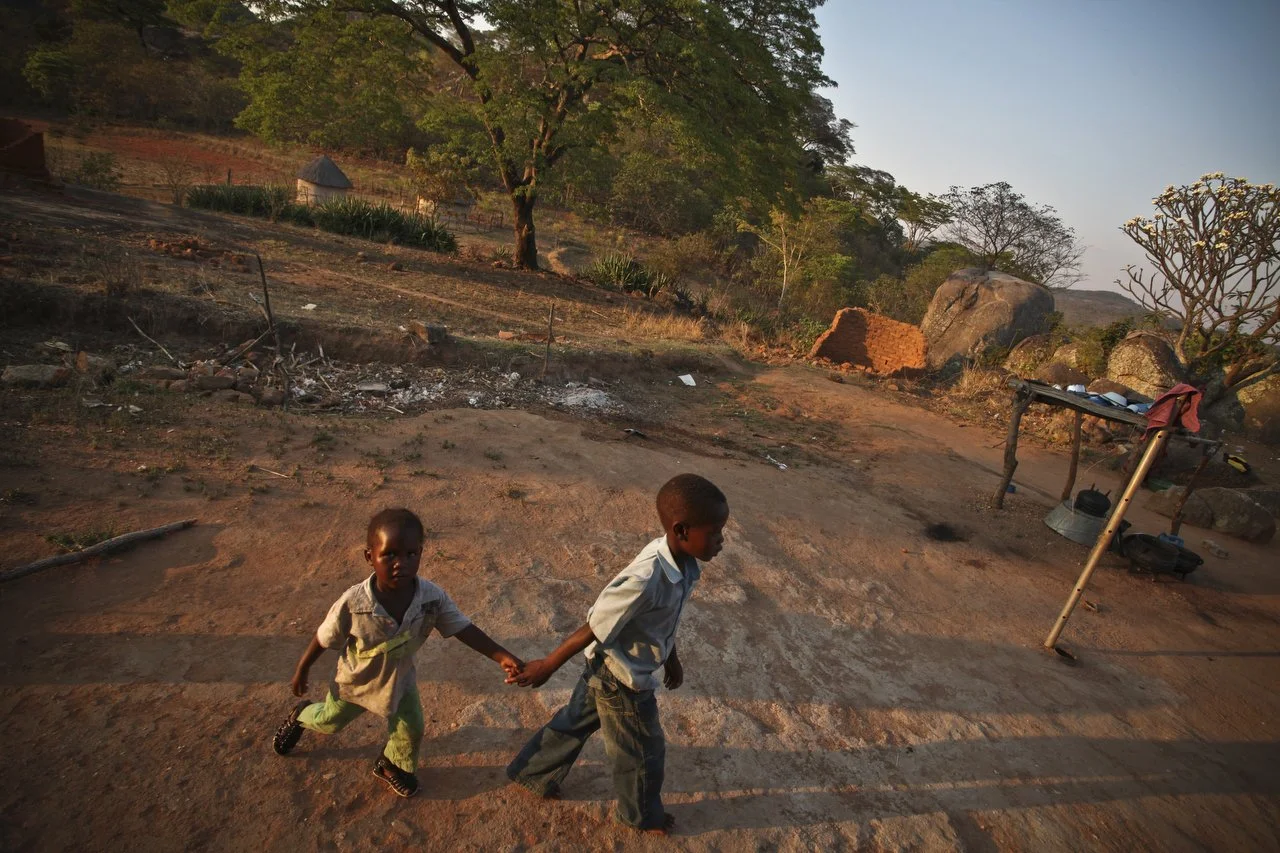  Kids walk to their mother in a village, located in the region of Bakita in Zimbabwe. The village is about a 40 minute hike from the closest shops. Thousands of Zimbabwean refugees crossed the border to South Africa to escape political turmoil, lack 