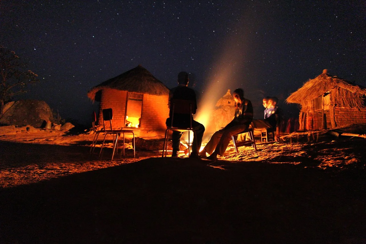  Men sit around a fire at night in a village, located in the region of Bakita in Zimbabwe. The village is about a 40 minute hike from the closest shops. Thousands of Zimbabwean refugees crossed the border to South Africa to escape political turmoil, 