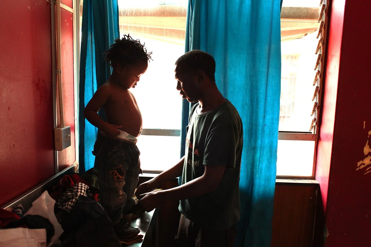  A father dresses his son in the morning at the Central Methodist Church in Johannesburg South Africa. The church has an official capacity of 1,500 people. At night, more than 2,000 patrons occupy every floor space available. The church has been a sa