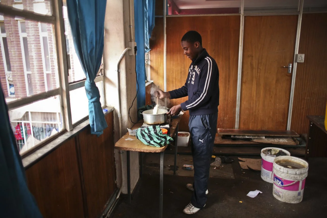  A young man cooks on the 3rd floor of the Central Methodist Church in Johannesburg South Africa. The church has an official capacity of 1,500 people. At night, more than 2,000 patrons occupy every floor space available. The church has been a sanctua