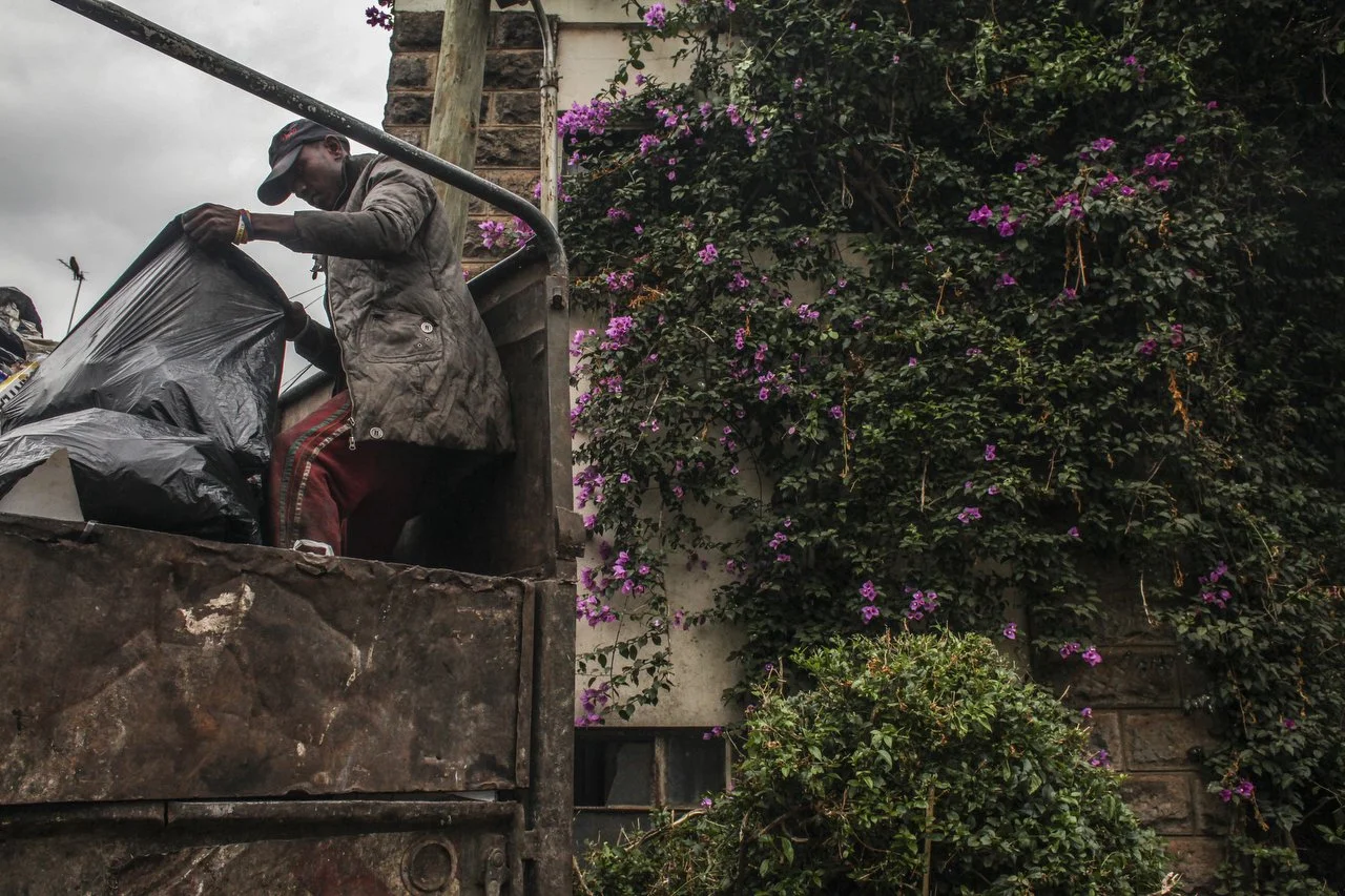  A private trash collection agency organizes trash in the back of the truck during a trash pickup run in Nairobi on June 29th 2013.  