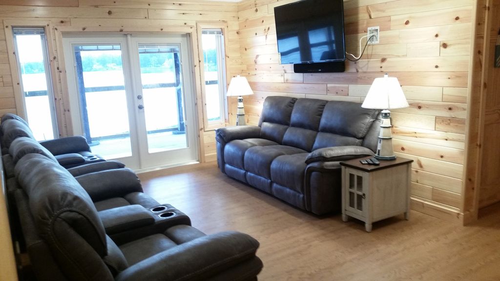 Walk-out level TV Room seats 7 w/ pwr recliners, 55" 4K TV, views of Stone Lake.