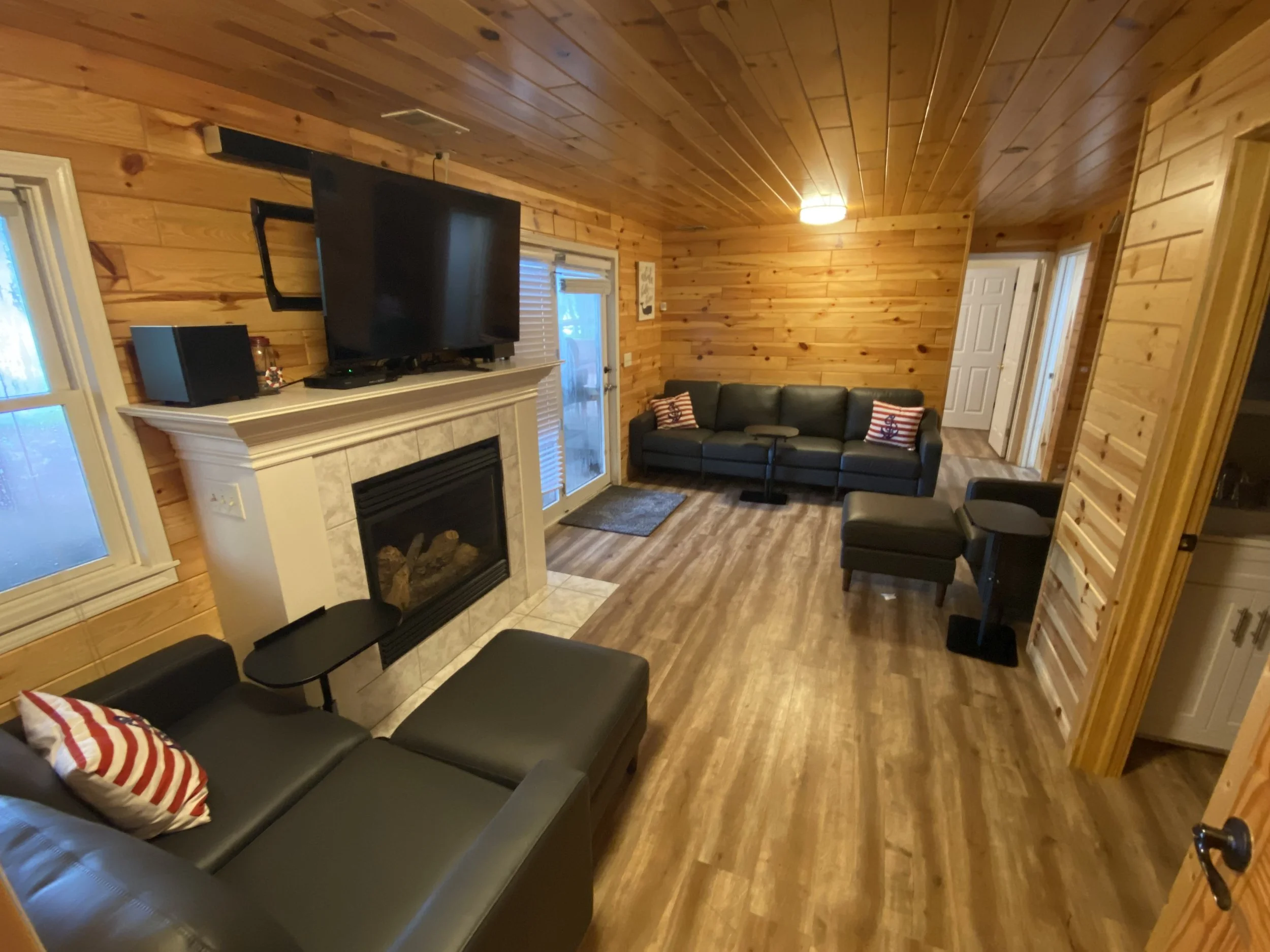  TV Room on walk-out level has gas fireplace, leather seating, 75" 4K Smart TV 