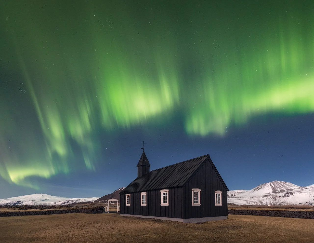 Iceland winter photo workshop featuring image of the Budir Church with northern lights