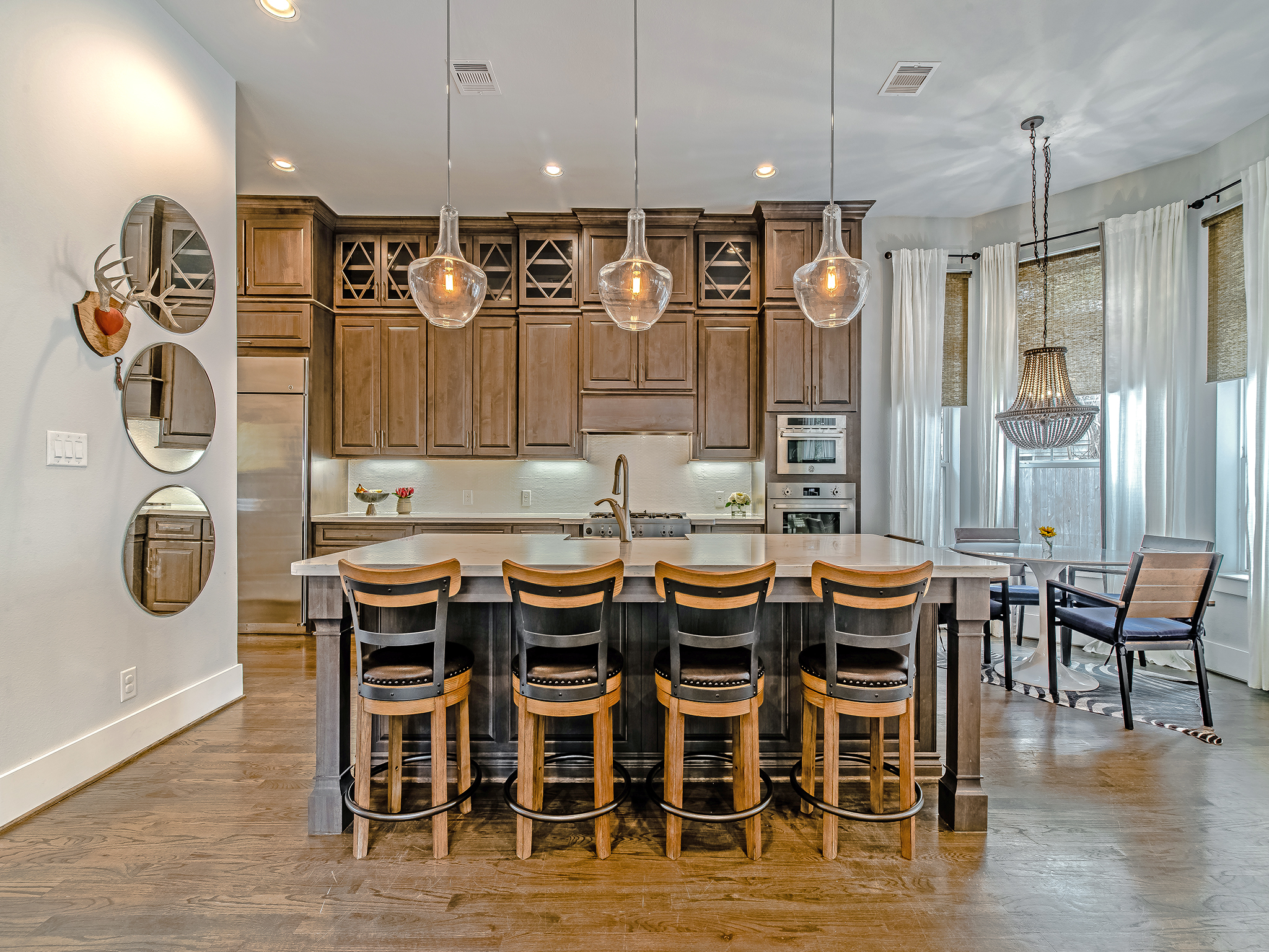 Ample island seating, breakfast nook, designer lighting make this kitchen a dream for entertaining.
