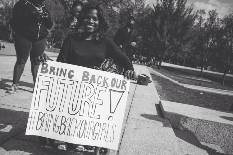 ola ojewumi Holding a banner, “bring back our future bring back our girls“ is written over banner