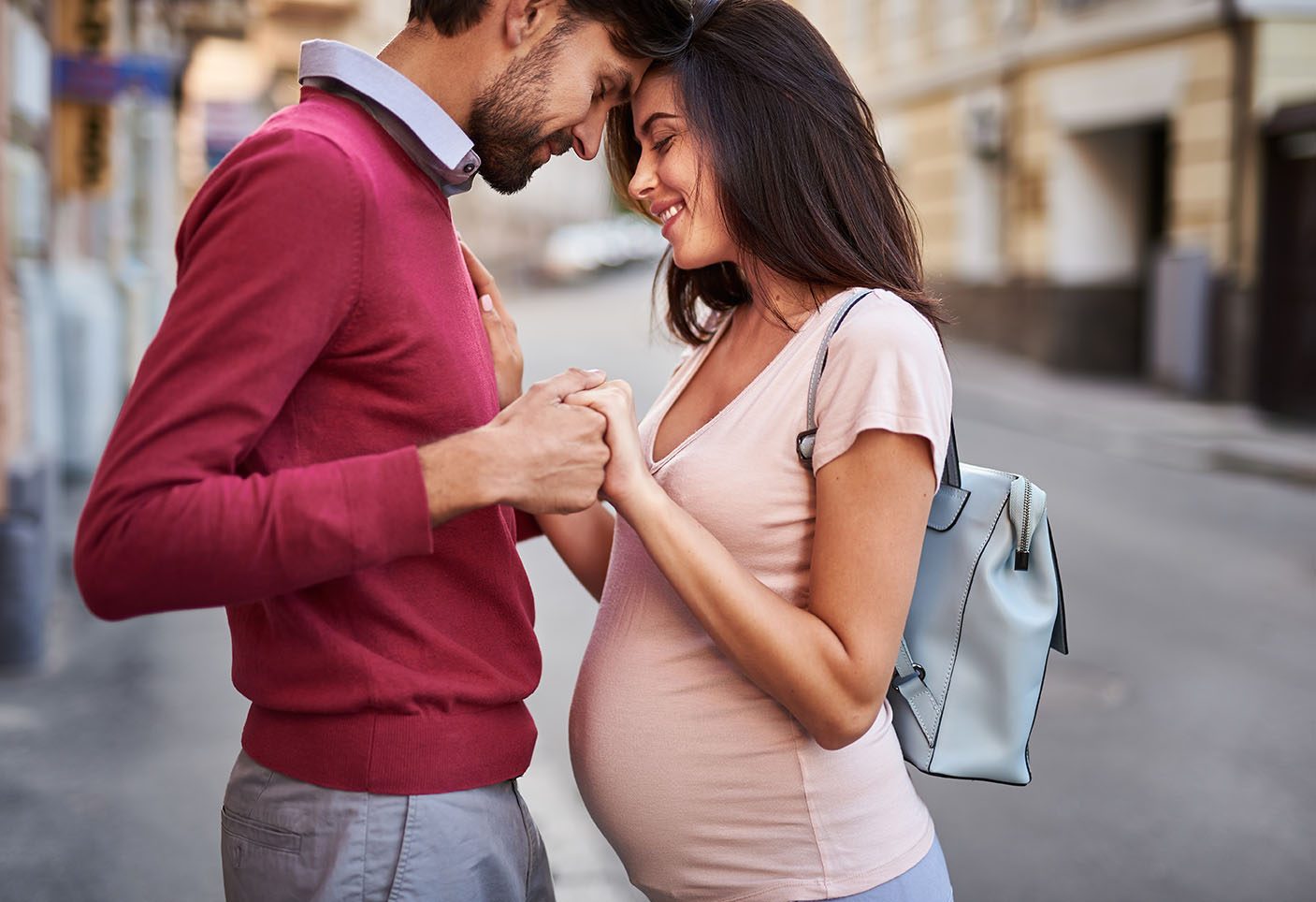 pregnant couple intimately connecting by holding hands.jpg