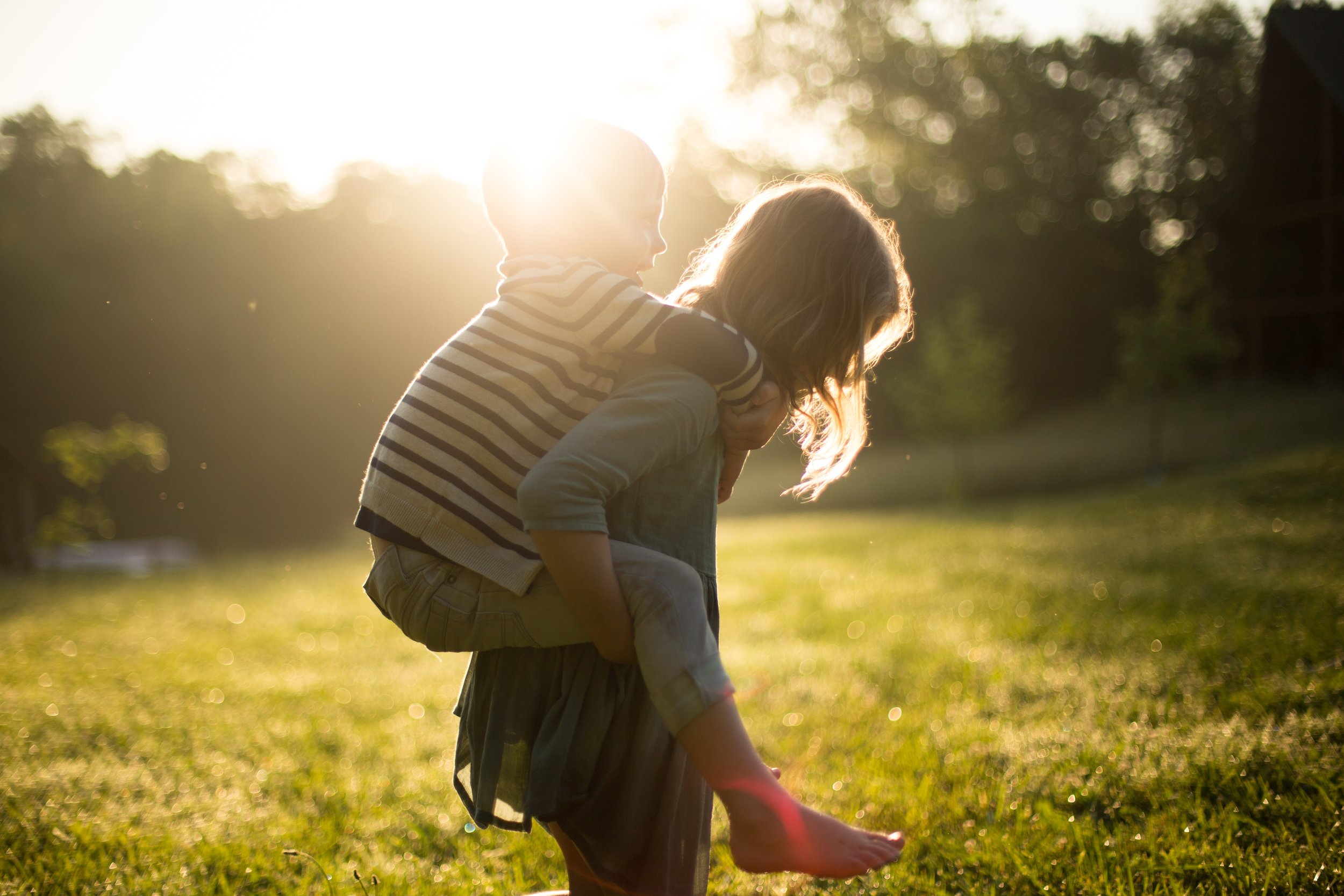 woman carrying child on her back in afternoon sunlight