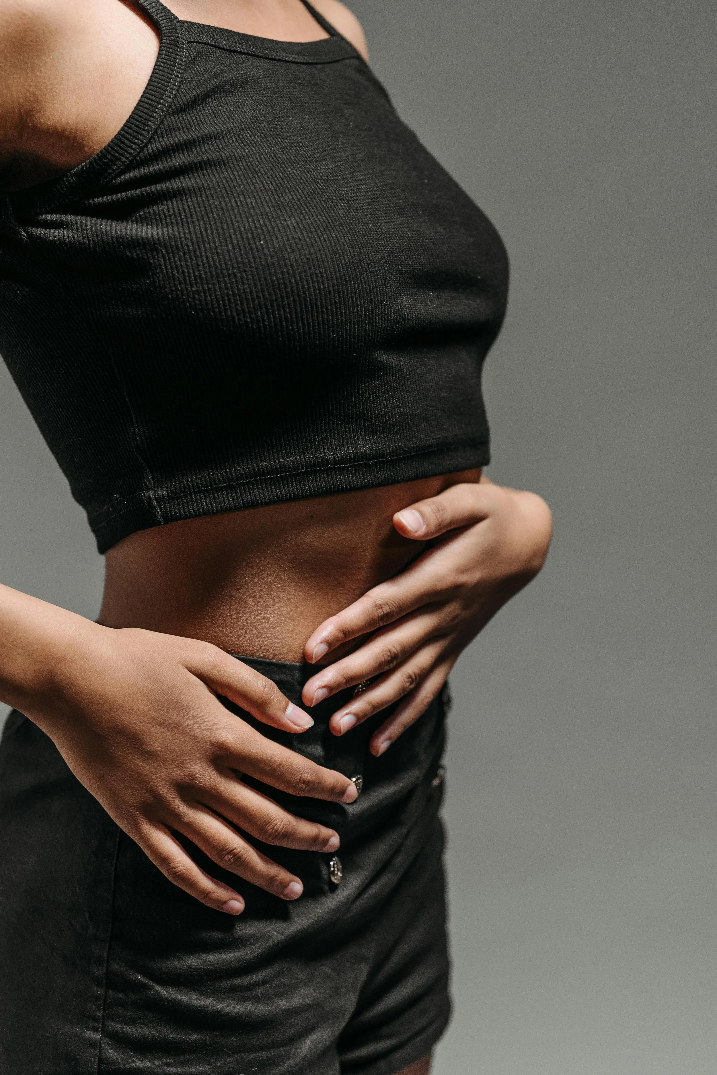 Close-up of a woman holding her lower abdomen, representing PCOS and fertility support at South Shore Acupuncture and Wellness, Rockland MA.